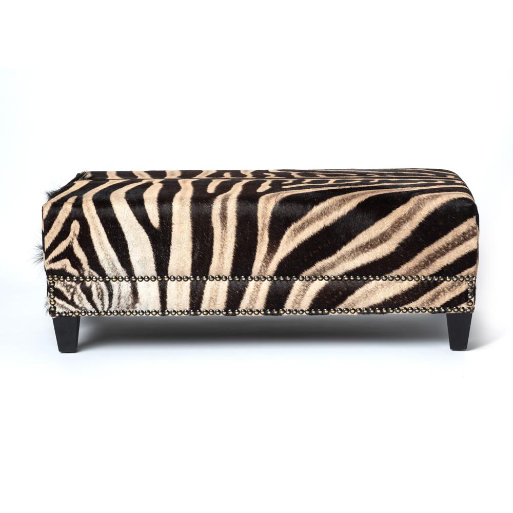 Decorative and functional, our ottoman is constructed with sustainabily sourced Burchell's Zebra hide. Complemented with a double border of nailheads. Due to the use of natural materials, each piece is unique and may vary slightly from image