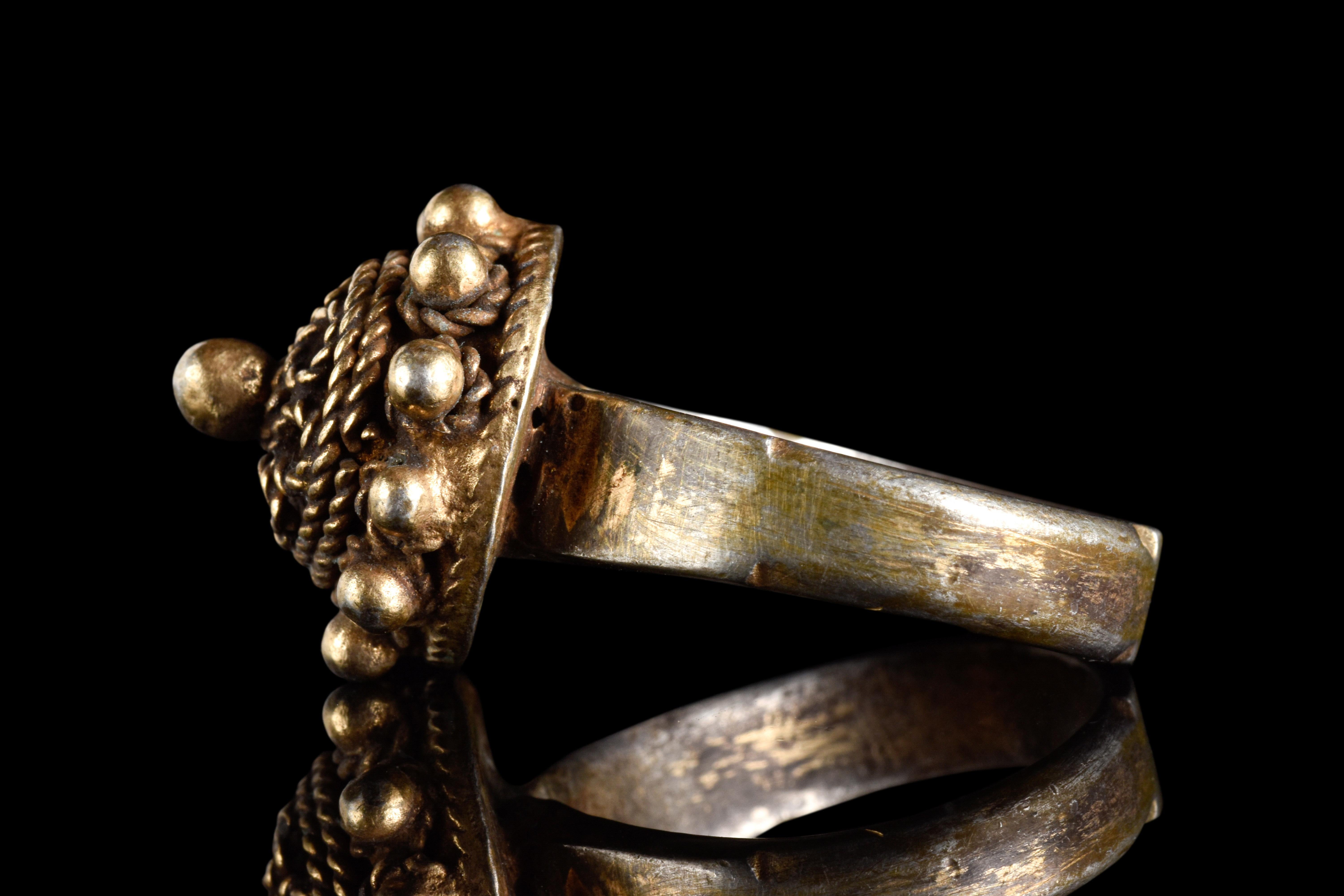 Ein silberner Fingerring, der die Exzellenz der osmanischen Handwerkskunst zeigt. Der flache Reif bleibt unverziert, während die kuppelförmige Lünette mit erhabenen Seilrändern und feinem Granulat versehen ist, die für Textur sorgen. 

Größe: