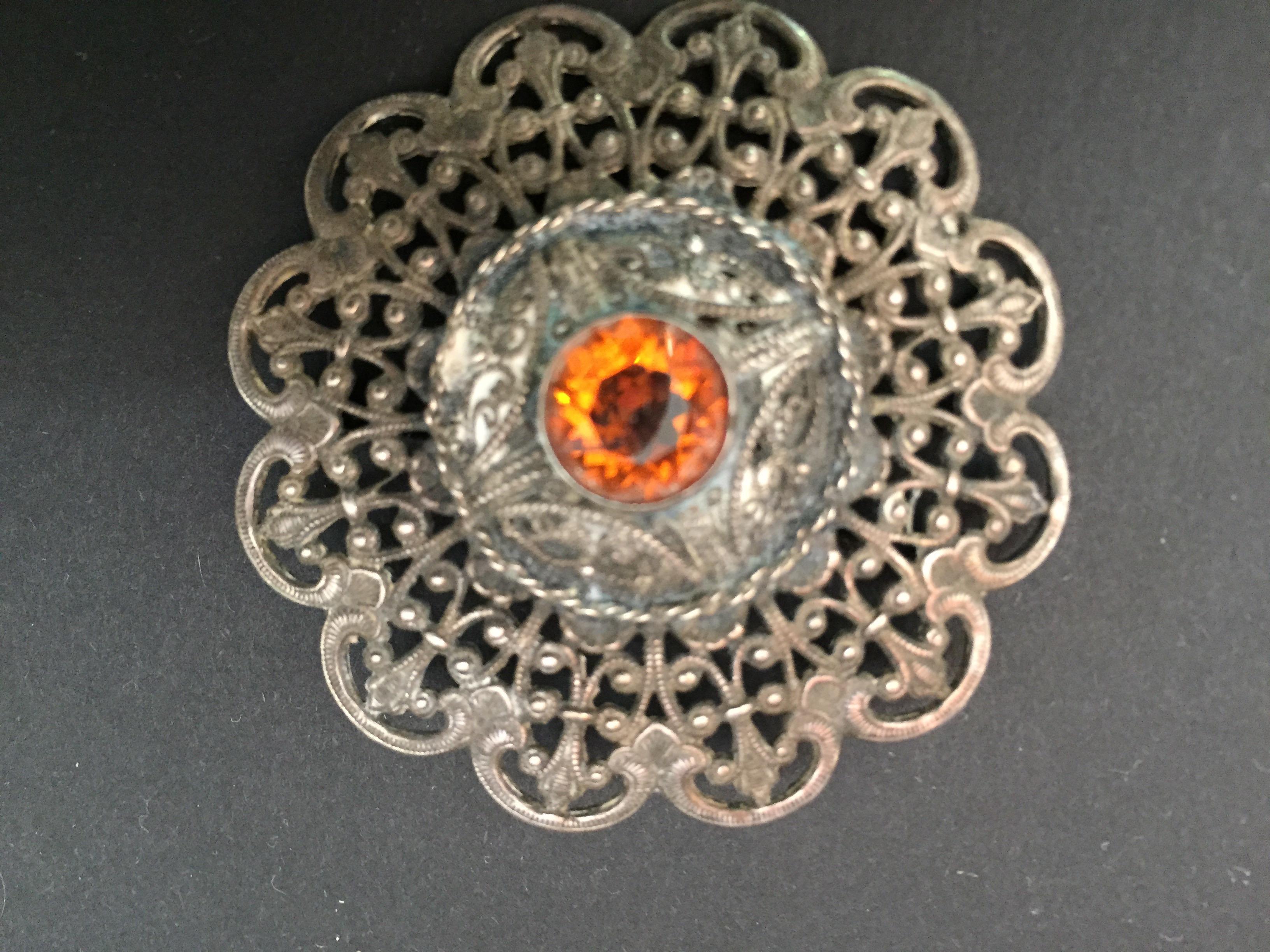 Collectible ottoman style Turkish German silver brooch or veil pin with Moorish filigree.
Middle Eastern collectible silver jewelry brooch pin in circular form.
Stunning 1940s brooch with citrine gemstone.