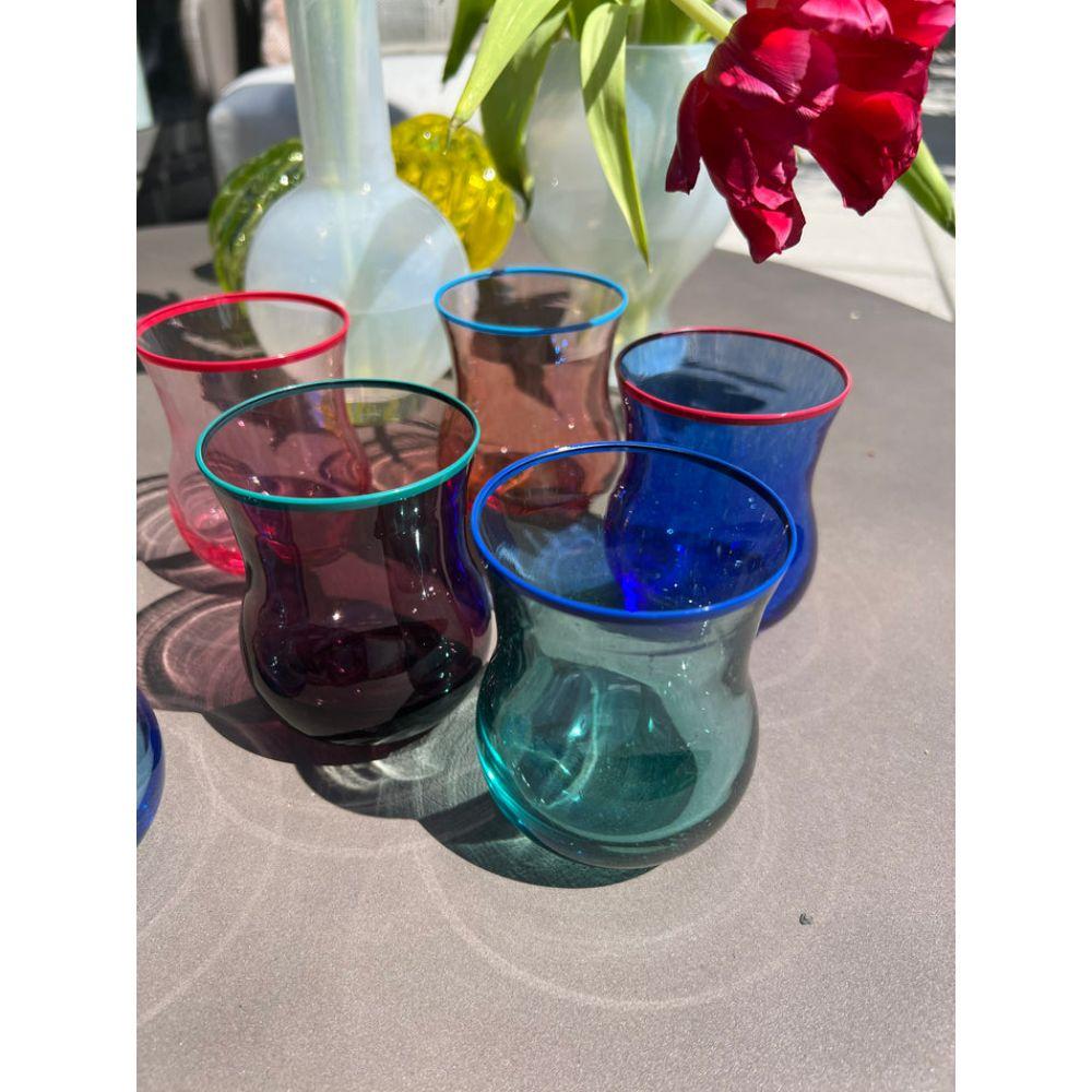 Mouth-blown tulip shaped glass tumblers in six colors- Turkish blue, cobalt blue, sunset, pink, tourmaline green, lime green, yellow and amethyst. The tumblers are finished with hand painted contrast rims which are heat sealed. Hand wash