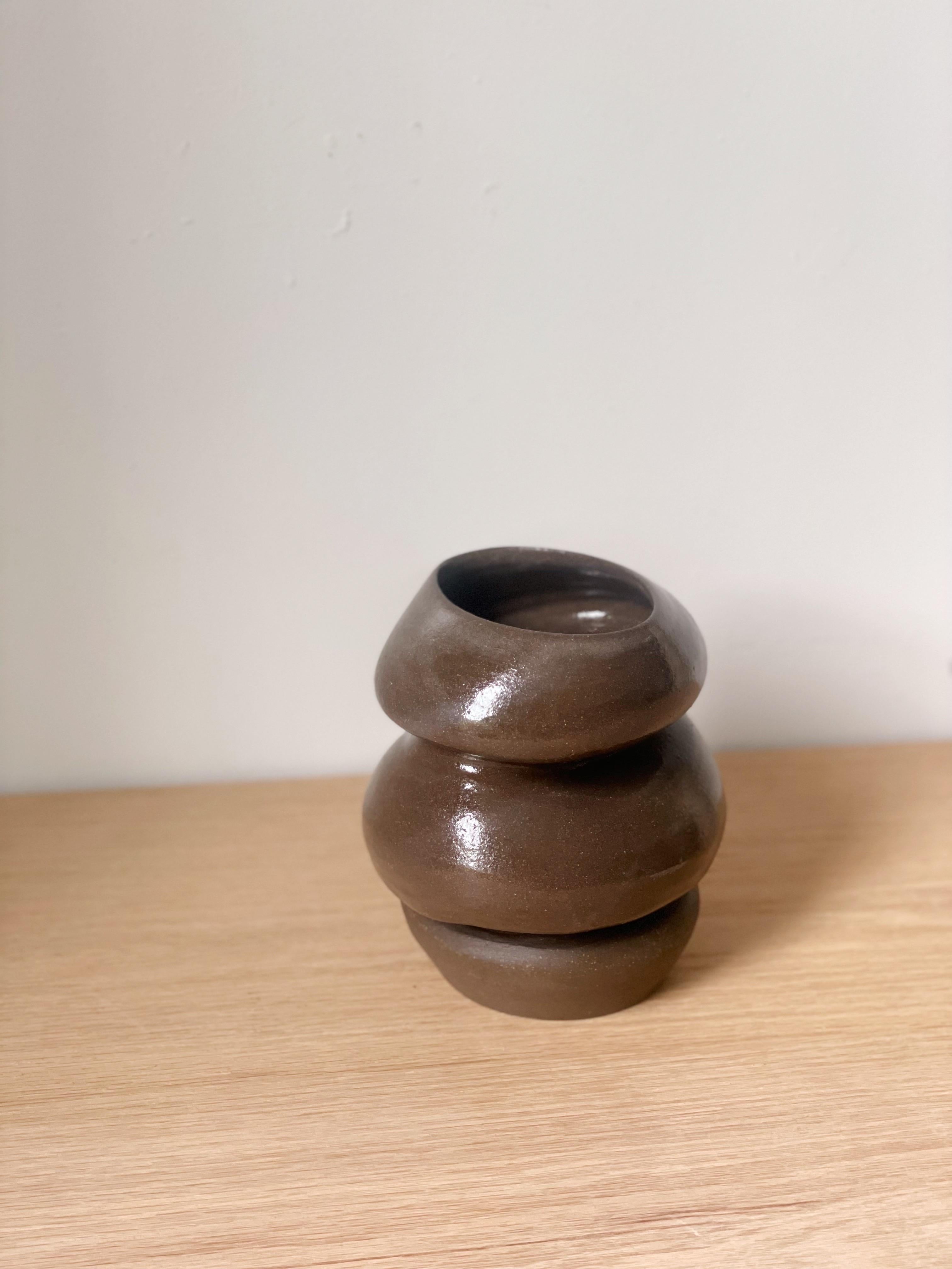 'oud vessel- This playful shape, combined with the neutral crackle glaze is such a fun piece, a perfect addition to your space. It is small and squished. Drawing a figural look from the overall form.

Made from a dark brown rich stoneware, with a