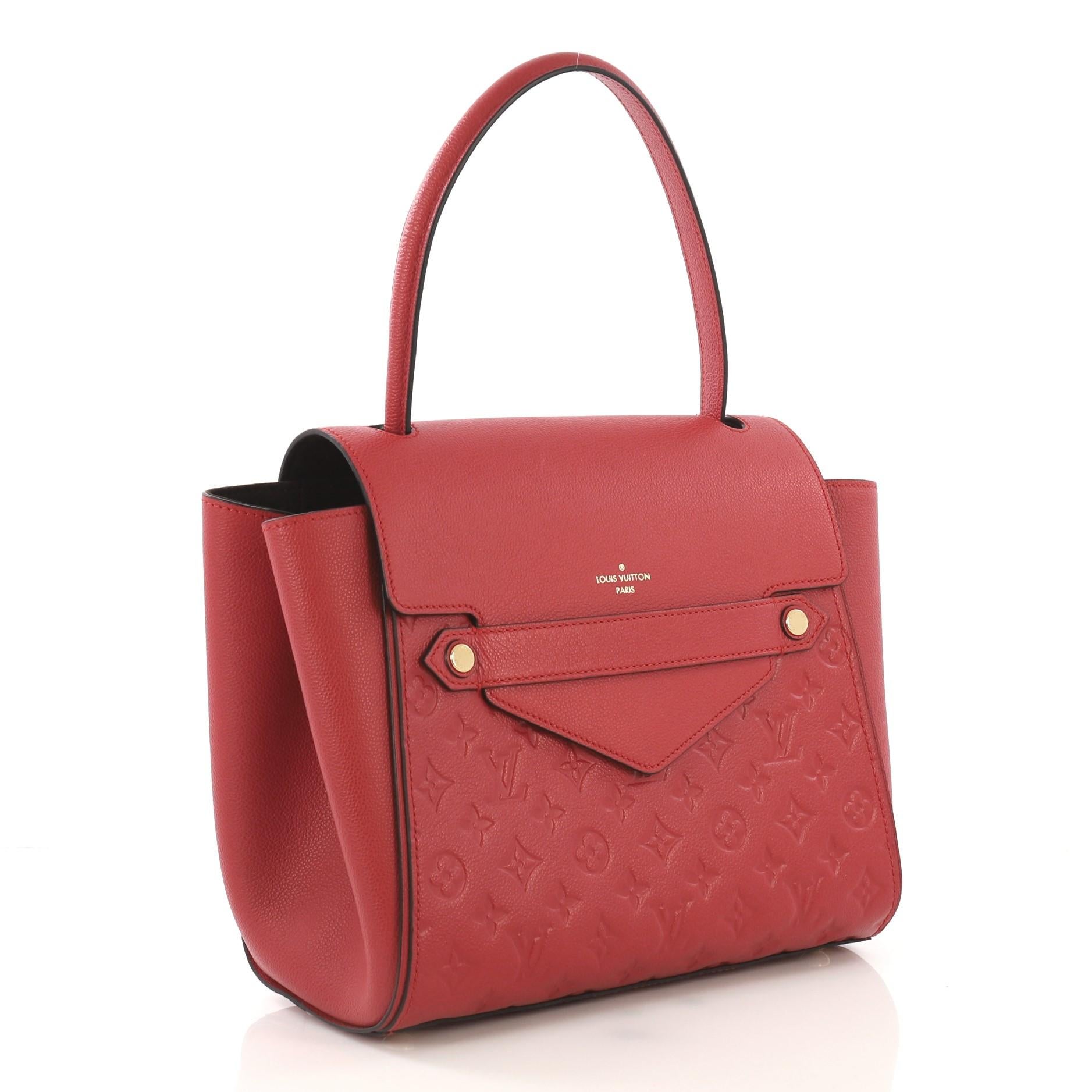 This Louis Vuitton Trocadero Handbag Monogram Empreinte Leather, crafted from red monogram empreinte leather, features a looping top handle, subtle LV logo at front, protective base studs, and gold-tone hardware. Its hidden magnetic closure opens to