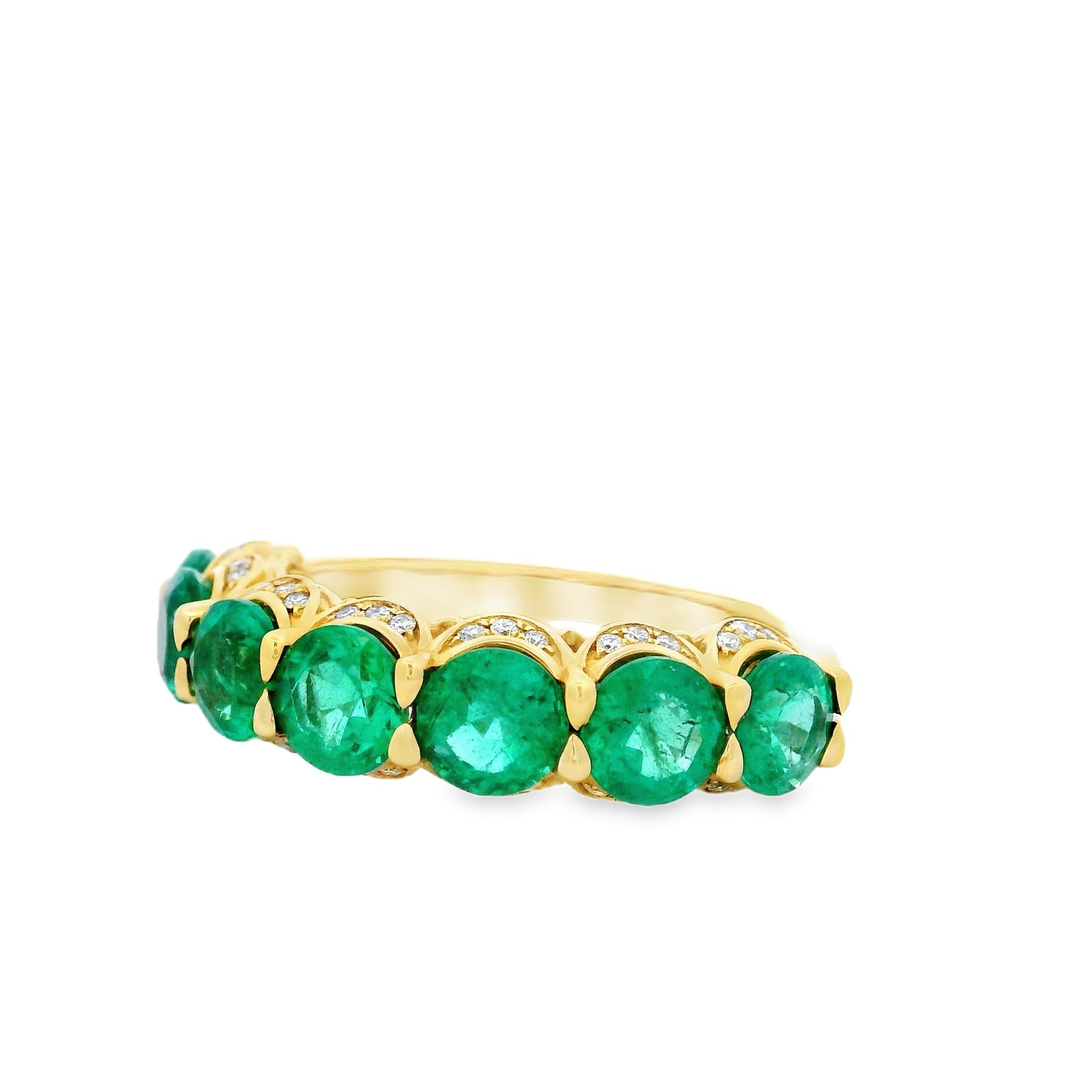 ibrant and luxurious, this emerald and diamond band ring makes a bold yet elegant statement. Seven vivid round-cut emeralds, each measuring 5.00mm, are claw-set across the band in 14K yellow gold. The lush green of the emeralds is beautifully offset