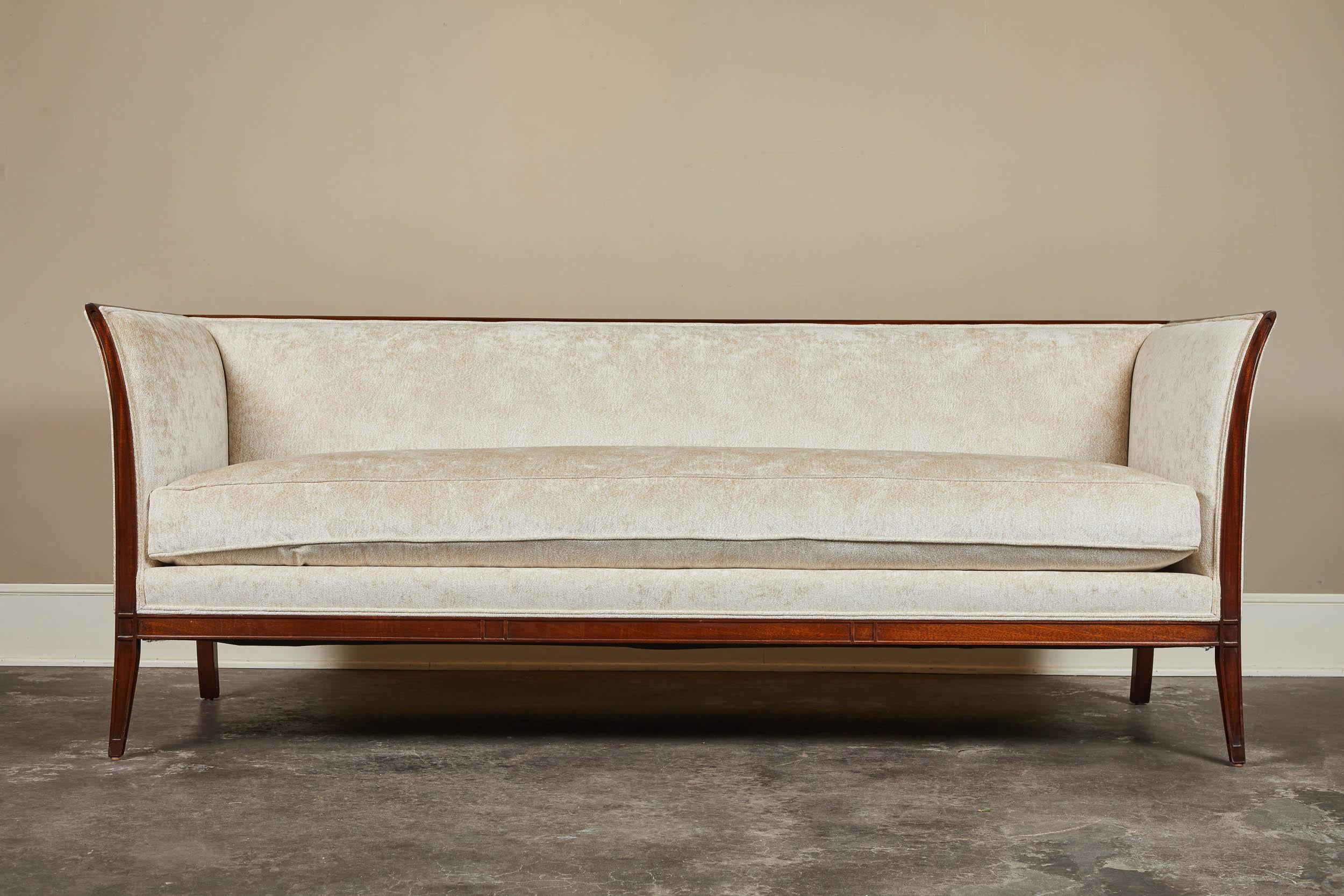 Our Albert sofa with mahogany trim. Recalling the neoclassical style of Sweden’s Gustavian era, this modern sofa features clean lines and a simple exposed frame of mahogany. The gently curved lines of the closed back and arms are carried downwards