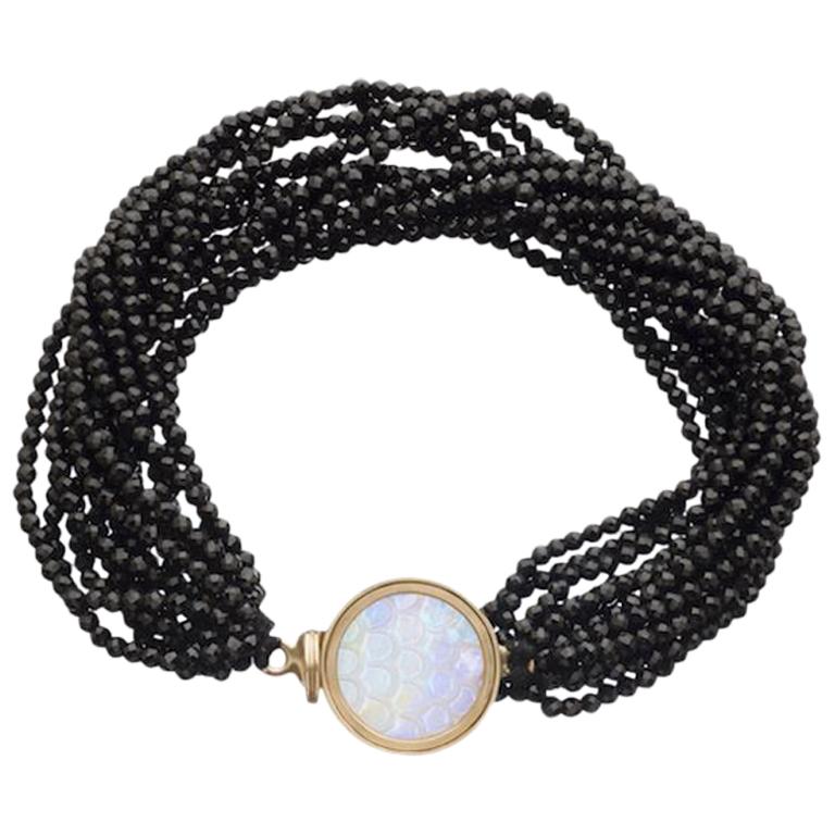 Ouroboros snake scale carved rainbow moonstone set in 18 karat gold with natural freshwater seed pearls or black spinels bead bracelets. 

These bracelets are completely made by hand and made to order, production time takes 4 to 6 weeks. 

OUROBOROS