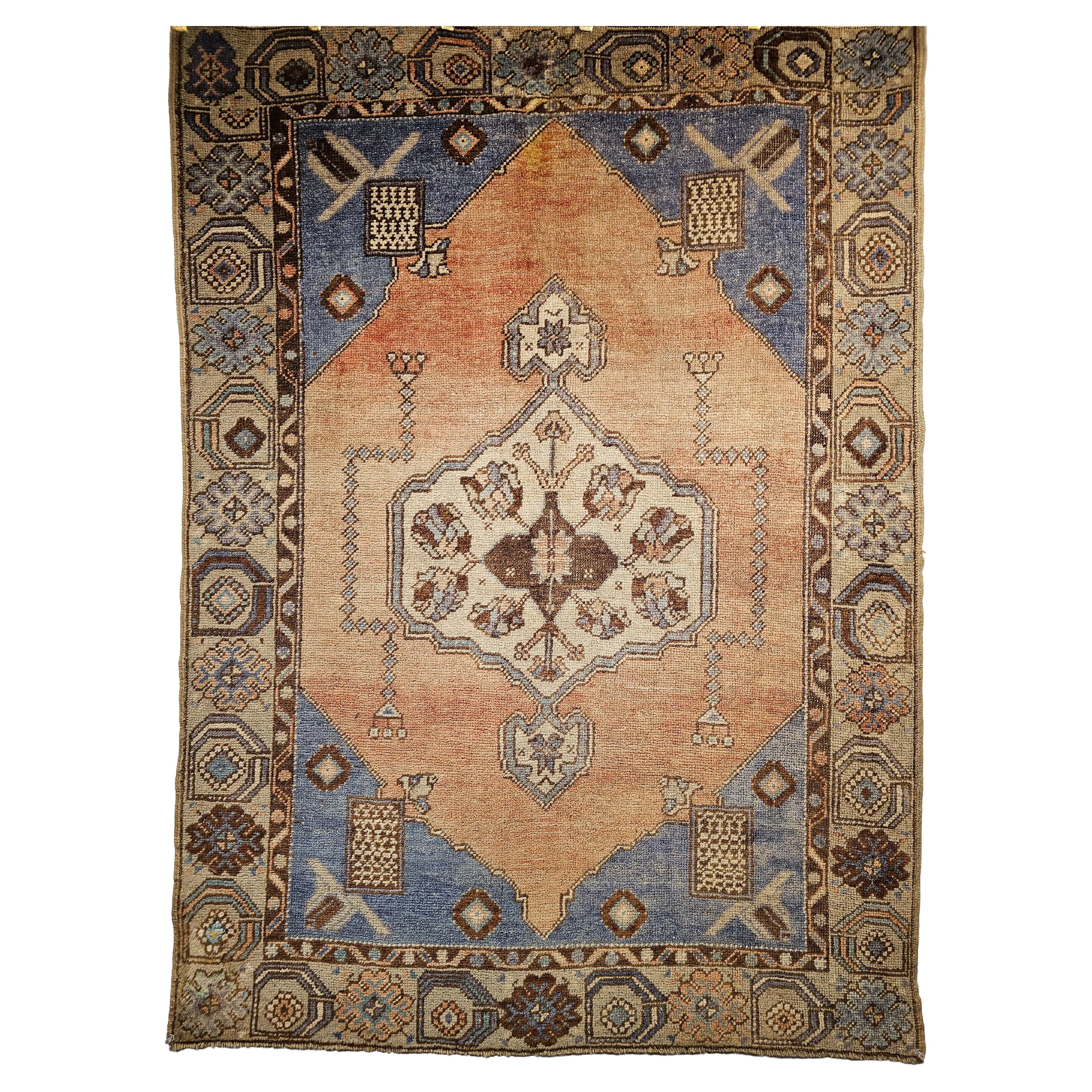 A beautiful Turkish Oushak area rug is from the mid 1900s in an open medallion pattern in an abrash pale salmon field with a cream color border.  The corner spandrels are in an abrash pale French blue color which has a brilliant tone. There is a