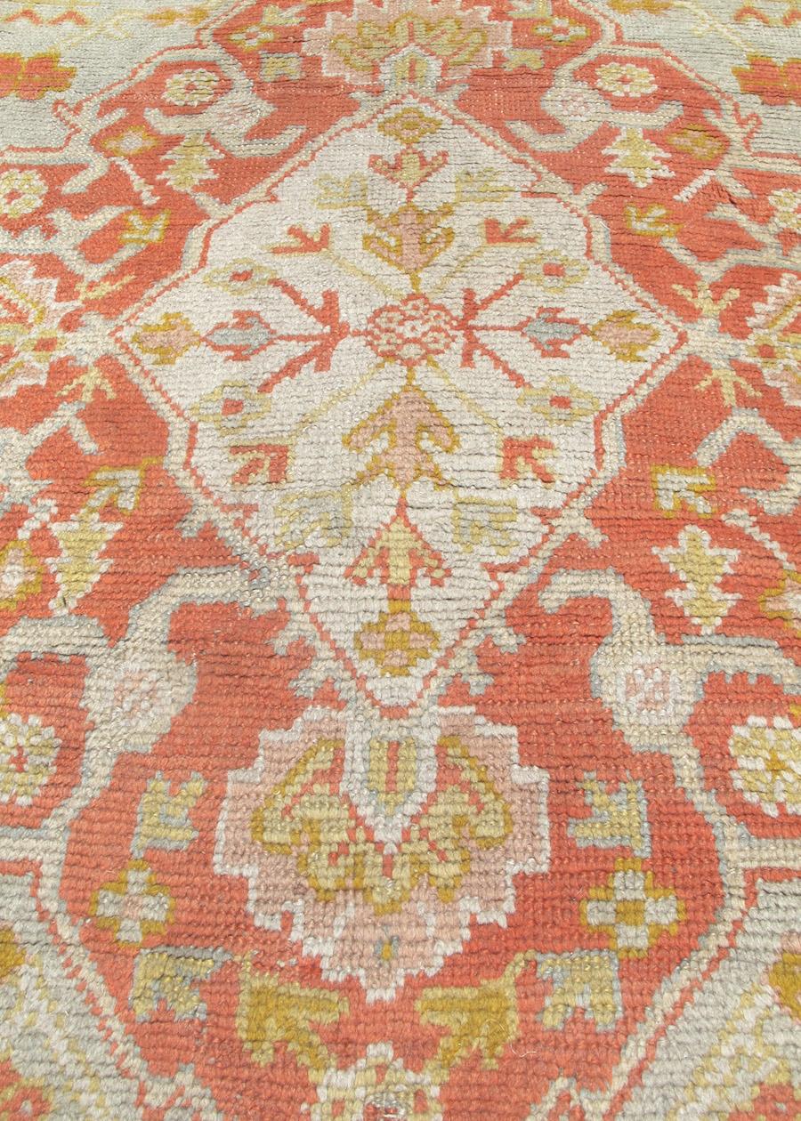 Oushak carpets are favored for their soft wool and pale coloration. Balancing a sky blue field with a border and central medallion woven in complementary contrasting shades of ocher and gold, this turn of the century Oushak is a decorative beauty. A