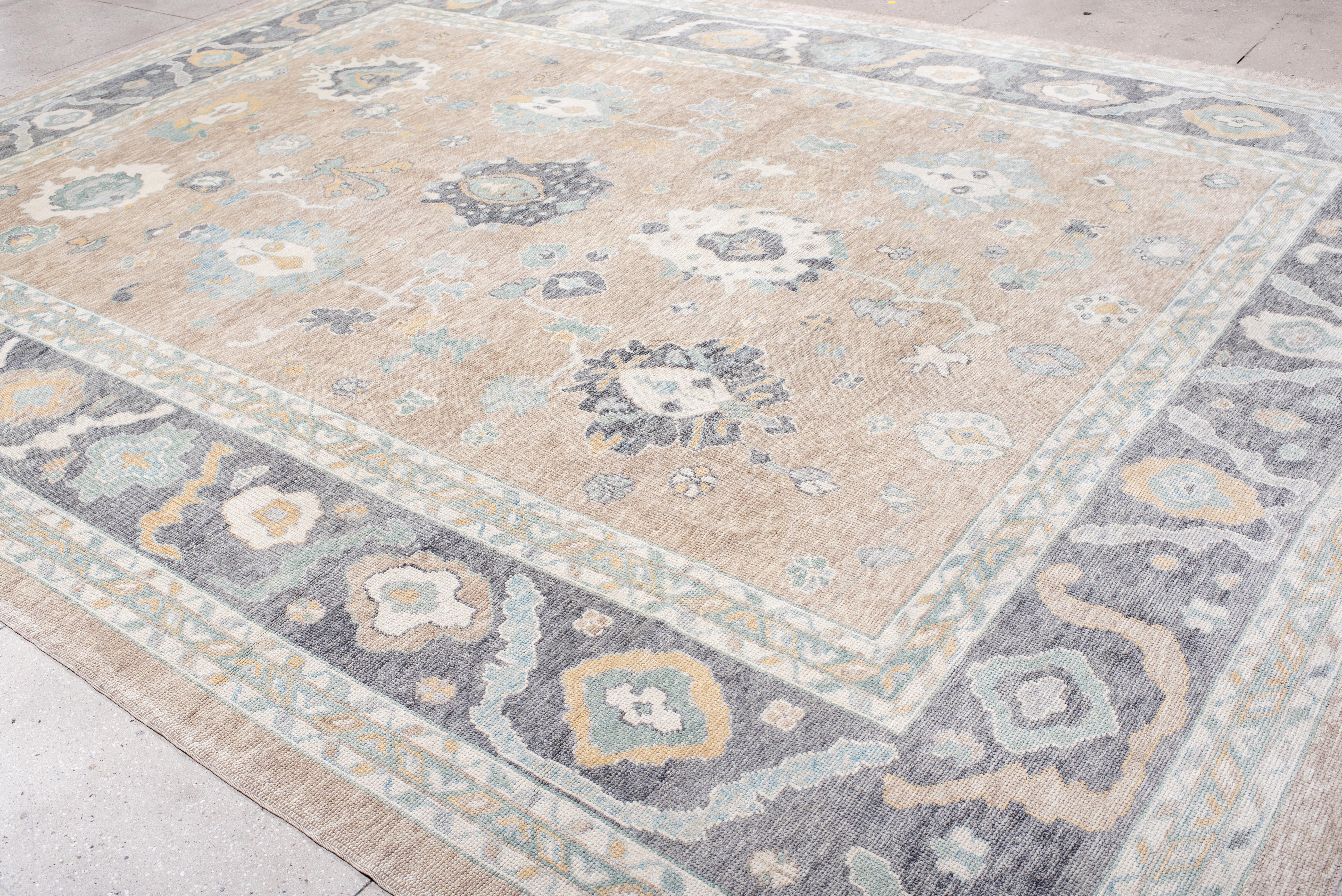 Fusion élégante de la tradition et de la modernité, ce tapis Oushak présente une composition doucement structurée avec des motifs botaniques flottants qui semblent à la fois organiques et intentionnels. Les proportions généreuses permettent à chaque