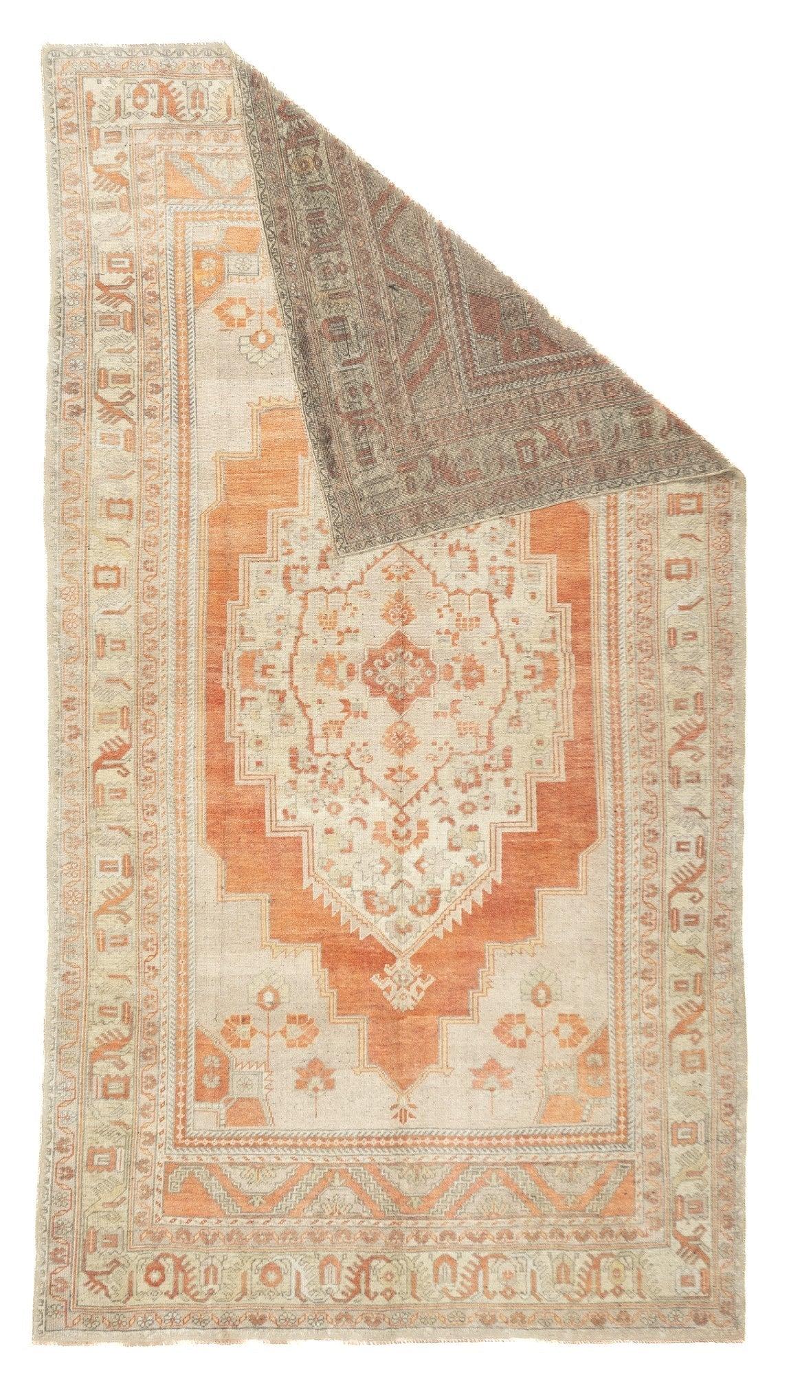 Oushak Teppich 5'9'' x 10'6''. Dieser rustikale Teppich zeichnet sich durch große, abgestufte, gemeinsame Puderecken aus, die in ein Feld übergehen, das ein schlichtes, abgewetztes helles Rost-Unterfeld umschließt. Das gestufte Medaillon in Form