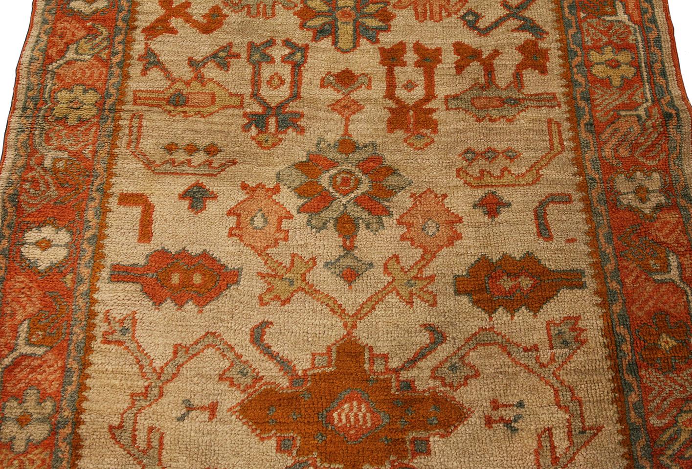 Questo tappeto Oushak, che misura 105 x 282 cm, esemplifica l'artigianato tradizionale turco con la sua tavolozza di colori tenui e gli intricati disegni geometrici. Le tonalità calde del beige, dell'arancione e del blu tenue conferiscono al tappeto