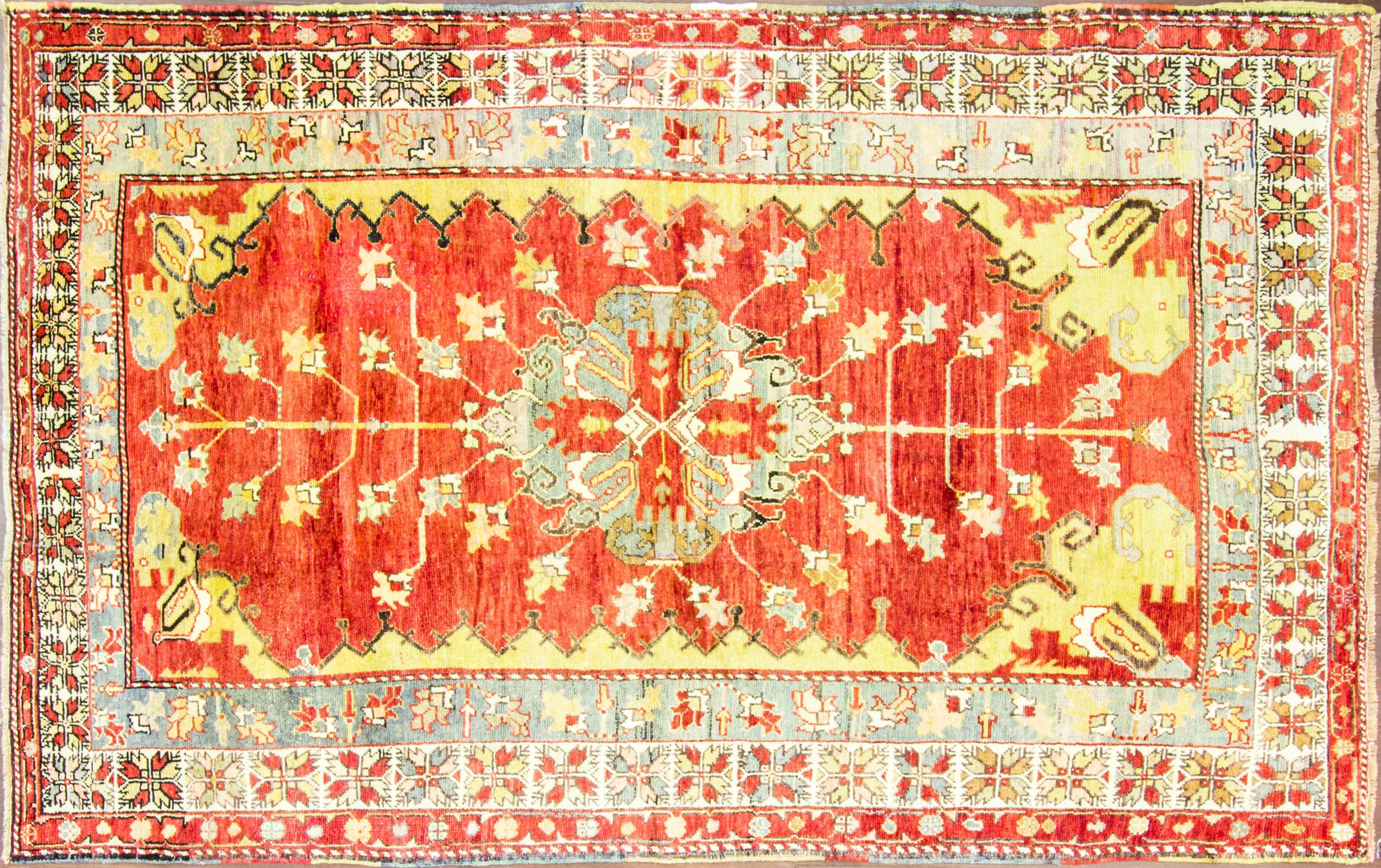 Vintage Oushak vegetable-dyed wool rug with floral and geometric motif, central medallion, and several borders. Measures: 5'9