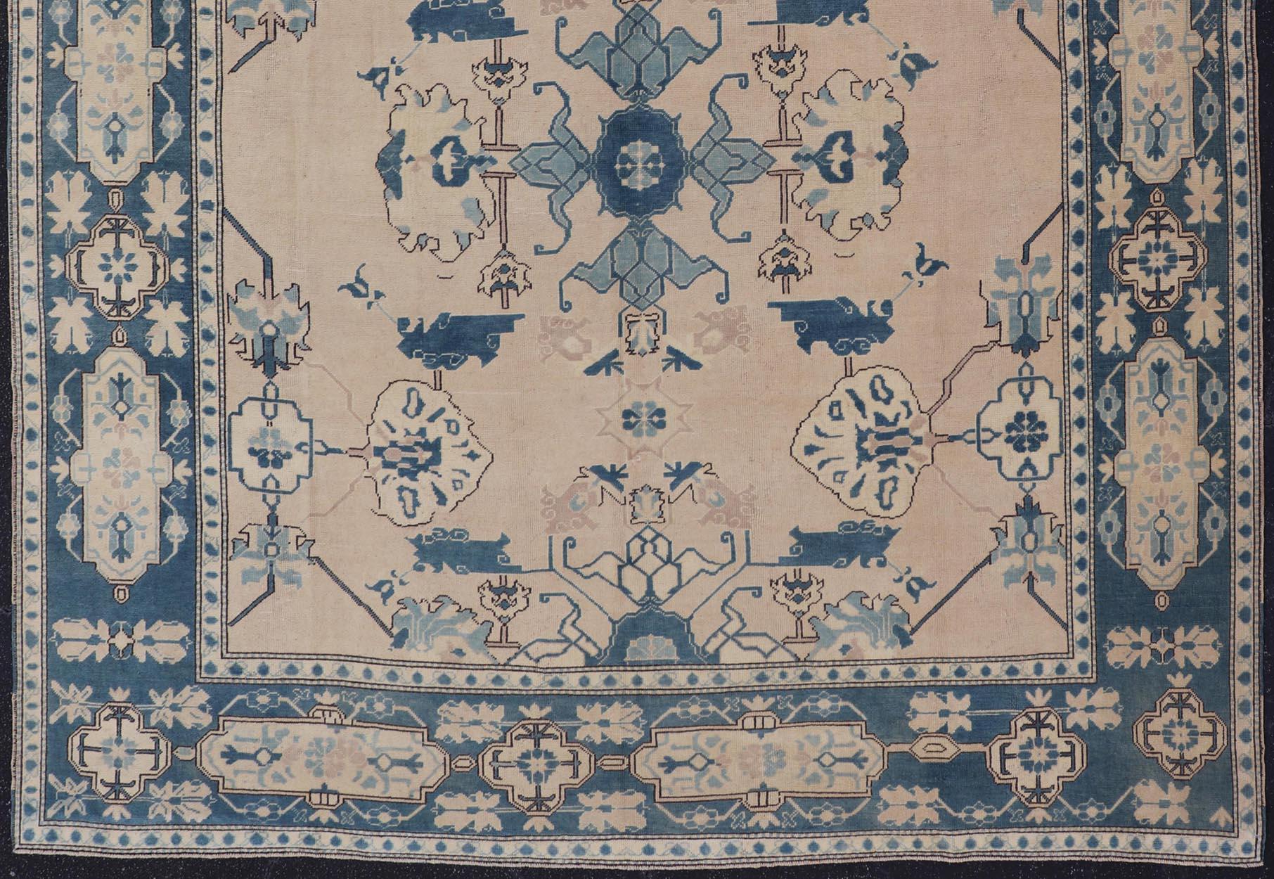 Measures: 10' x 12'4.
Vintage Turkish Oushak in cream and blue. Keivan Woven Arts /  rug en-165875, country of origin / type: Turkey / Oushak, circa 1940

This tribal design Oushak carpet features an array of motifs expanding across the central