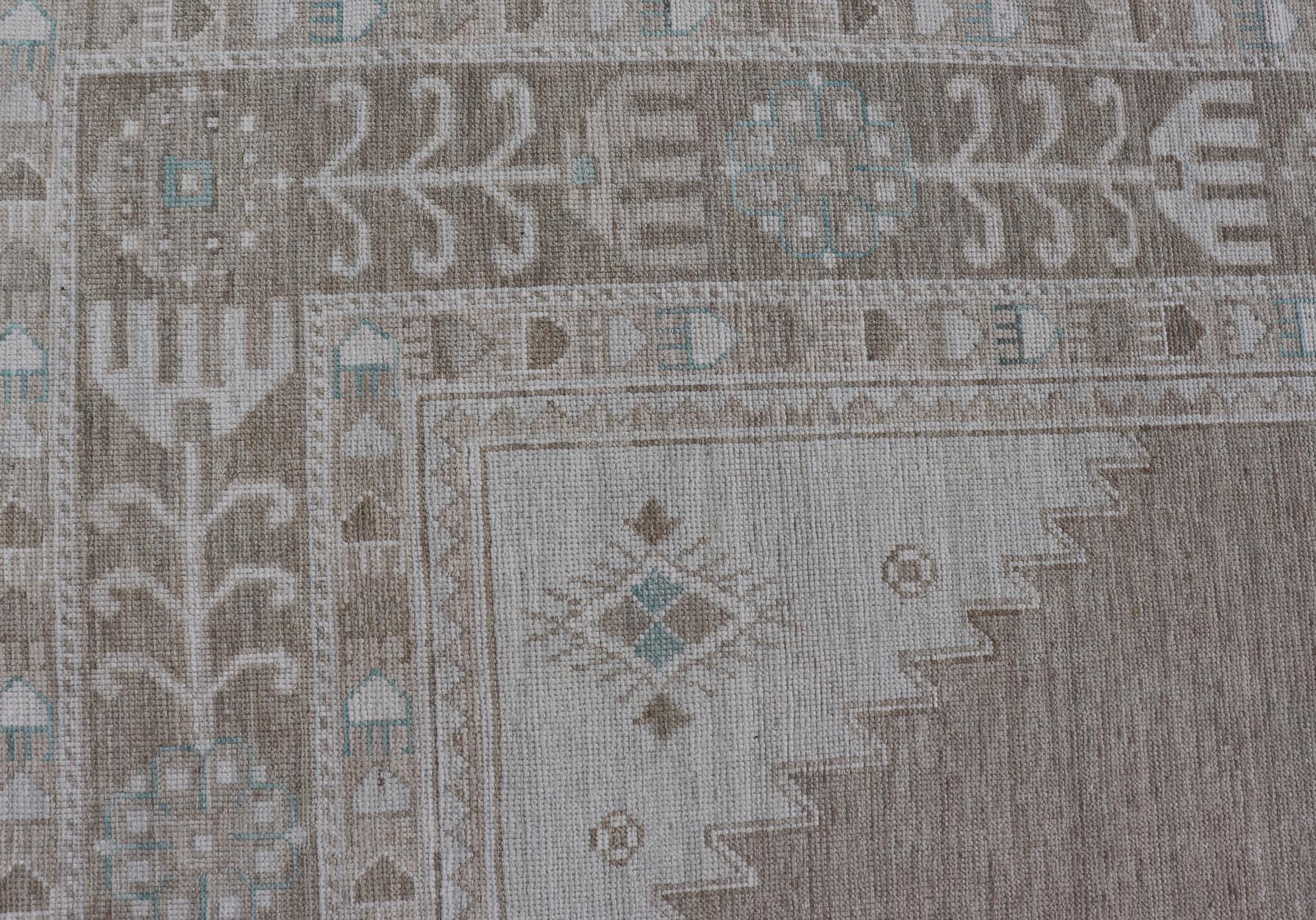 Maße: 10'0 x 14'4 
Oushak-Teppich mit taupefarbenem Grund und weichen elfenbeinfarbenen und hellblauen Akzenten 10'0 x 14'4. Keivan Woven Arts. Teppich /AWR-29 / Anfang 21. Jahrhundert, Türkischer Oushak.

Dieser moderne Oushak-Teppich zeigt ein