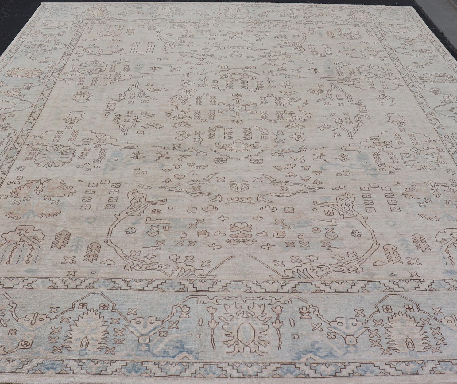 Misure: 11'10 x 14'5 

 Tappeto Oushak con campo avorio e blu tenue, grigio e marrone 11'10 x 14'5. Tappeto Keivan Woven Arts /AWR-443 / Inizio XXI secolo, Oushak.

Tappeto moderno in Oushak con campo avorio chiaro e sfumature tortora, blu tenue e