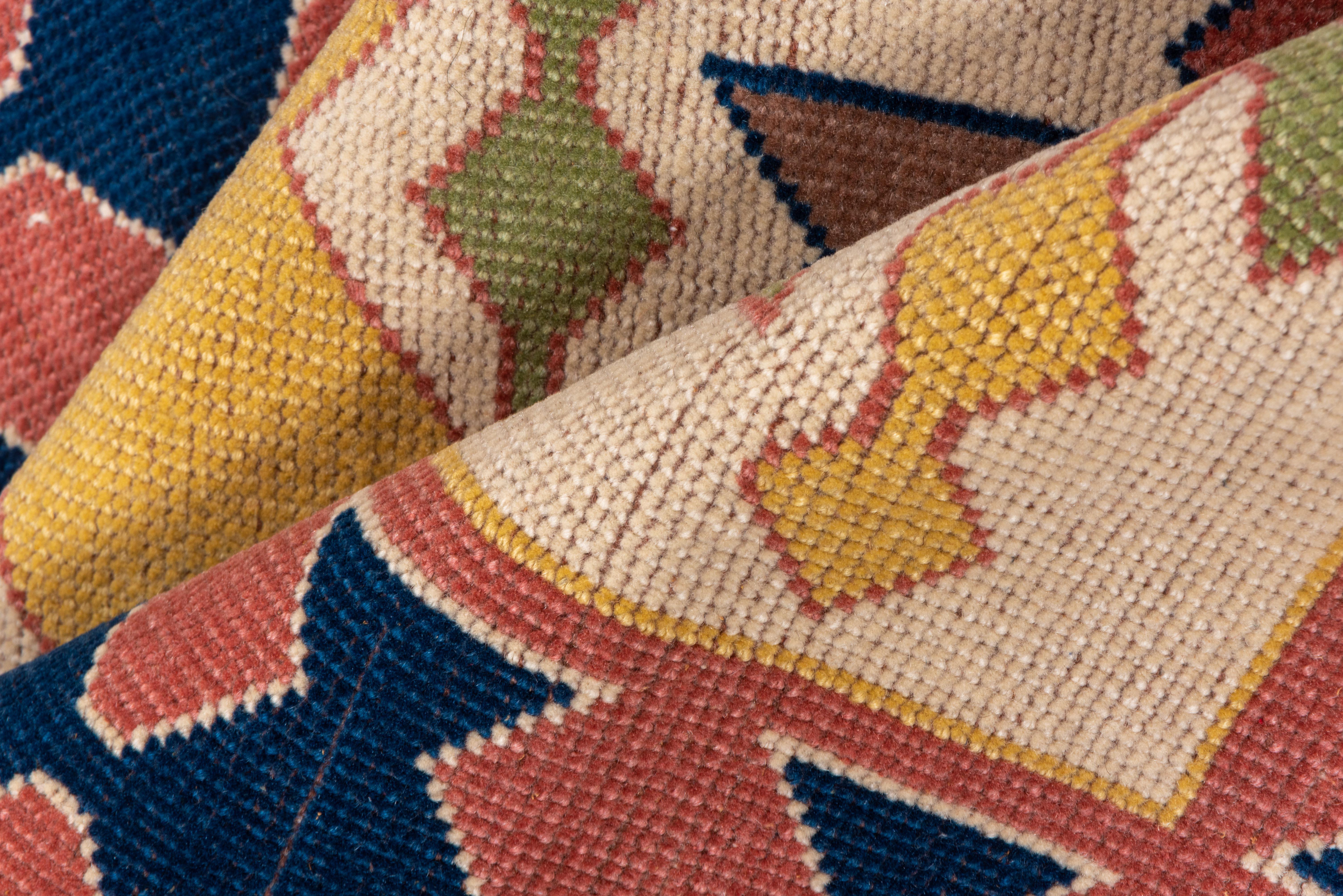 Questo straordinario runner Oushak presenta un audace motivo tribale geometrico reso in una tavolozza moderna e giocosa di ocra, verde bosco, fard, blu e avorio. La colonna centrale con forme stilizzate a zig zag è affiancata da un bordo ritmico di