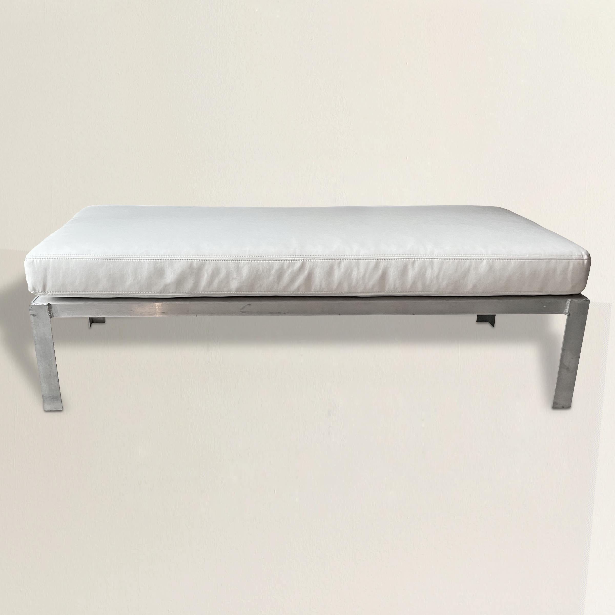 A simply but chic 20th century American industrial aluminum bench with a custom faux leather upholstered outdoor cushion. The perfect bench by your pool, or ottoman in front of an outdoor or indoor sofa.