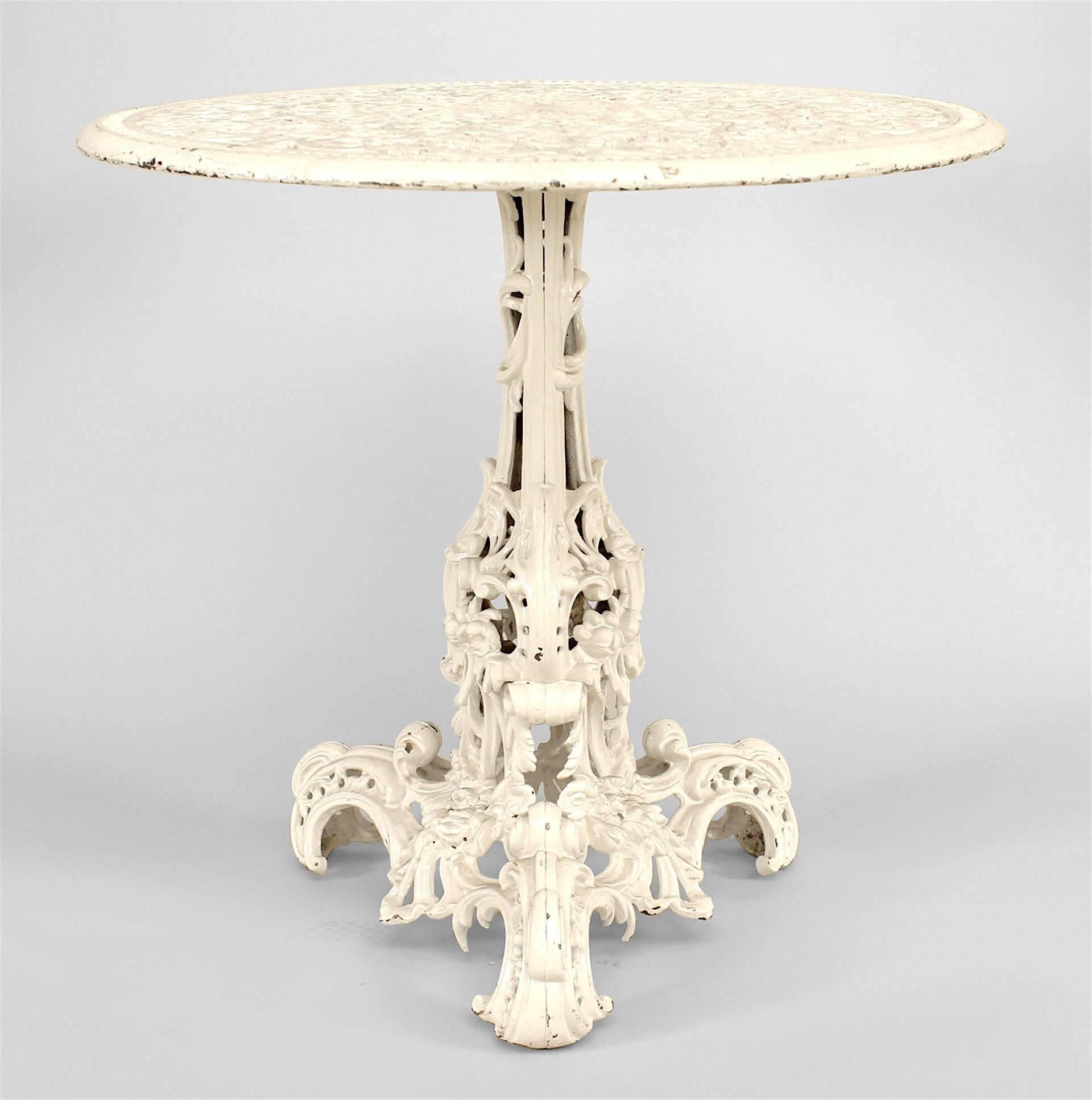 Outdoor American Victorian painted iron round center table with filigree and scroll design top and pedestal base.
