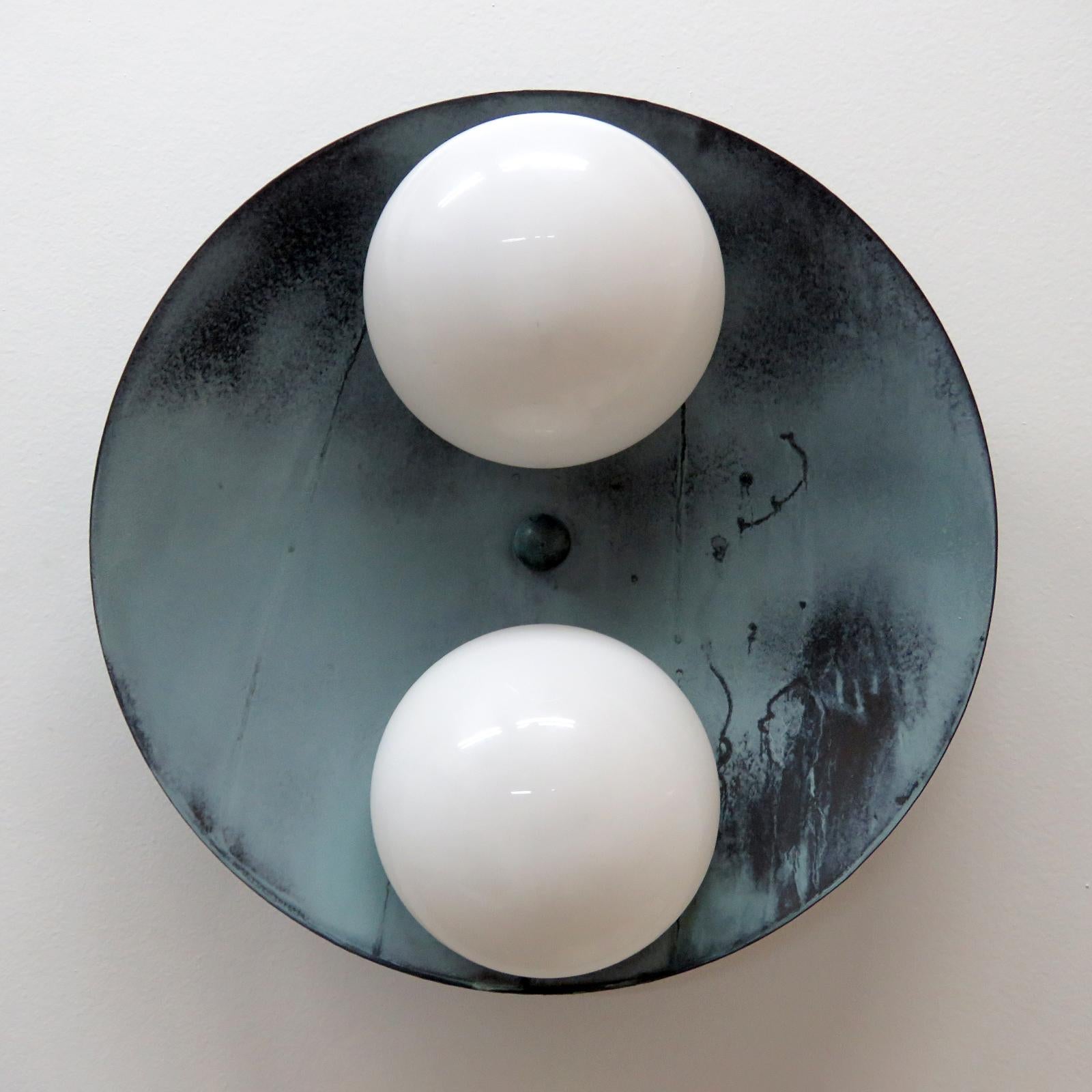 Elegant Binova outdoor wall/ceiling light designed by Gallery L7, handcrafted and finished in Los Angeles from American brass, with two opaline glass shades on a verde gris patina brass disc. Available with gloss or satin glass shade (gloss