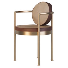 Sillón de comedor para exterior con detalles dorados y tapicería de piel