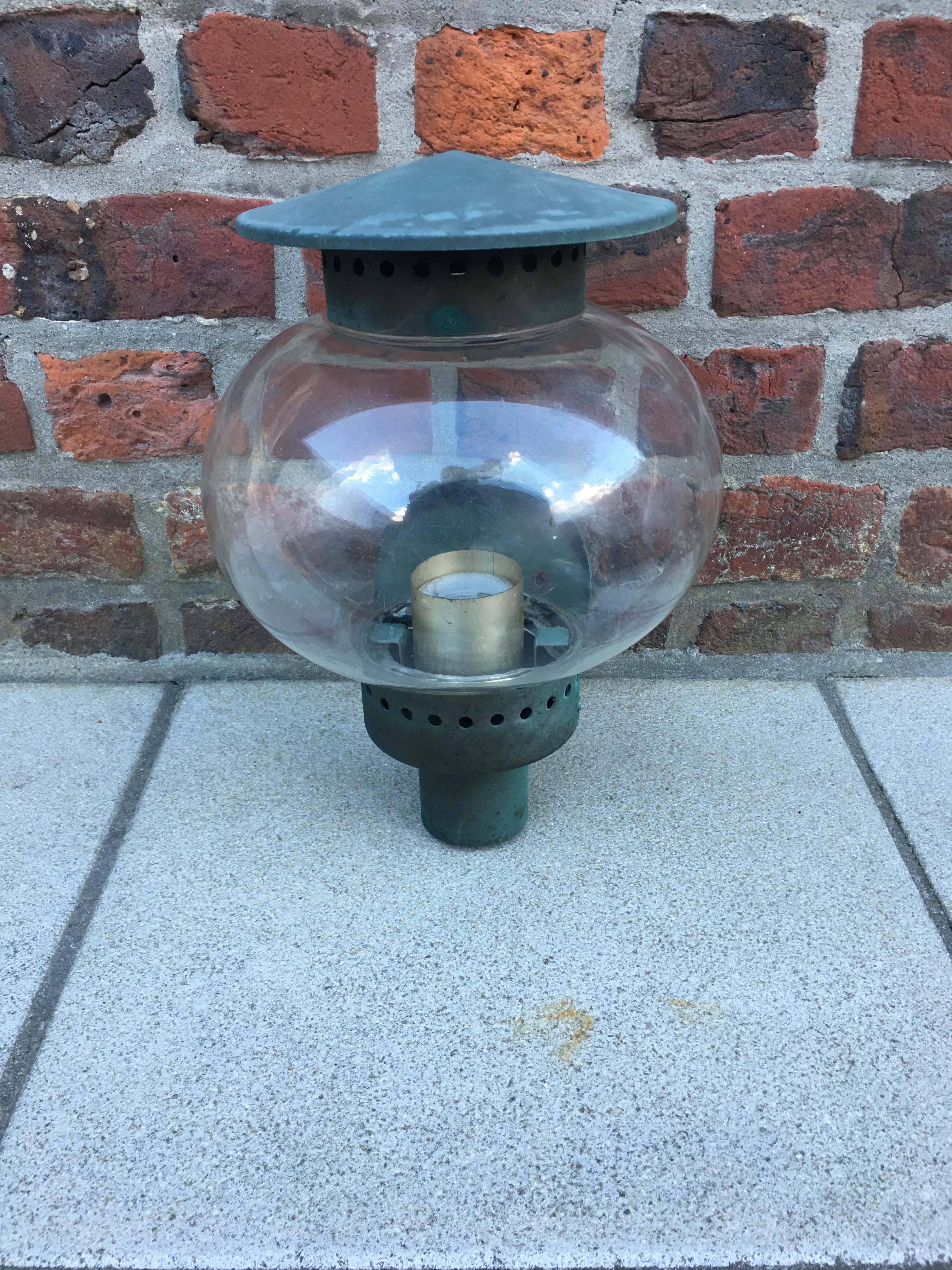 Lampe d'extérieur d'époque Art déco, attribuée à Jean Perzel, vers 1930.
Bon état, oxydation et patine d'usage.
L'électrification à l'étude.
 