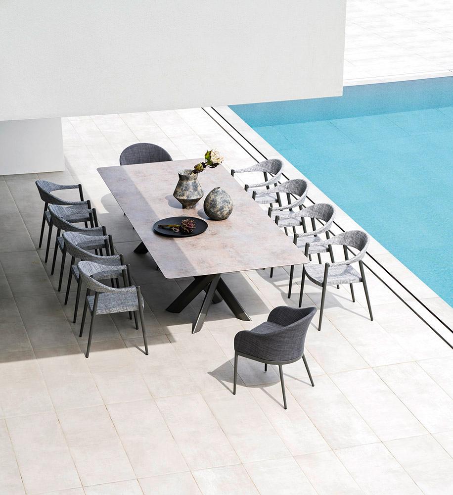 The System Star tables, available in maxi and maxi long versions, are designed for social gatherings. The large tabletop is supported by two elliptical bases, featuring legs that intertwine in a star-like pattern, a signature motif of the System