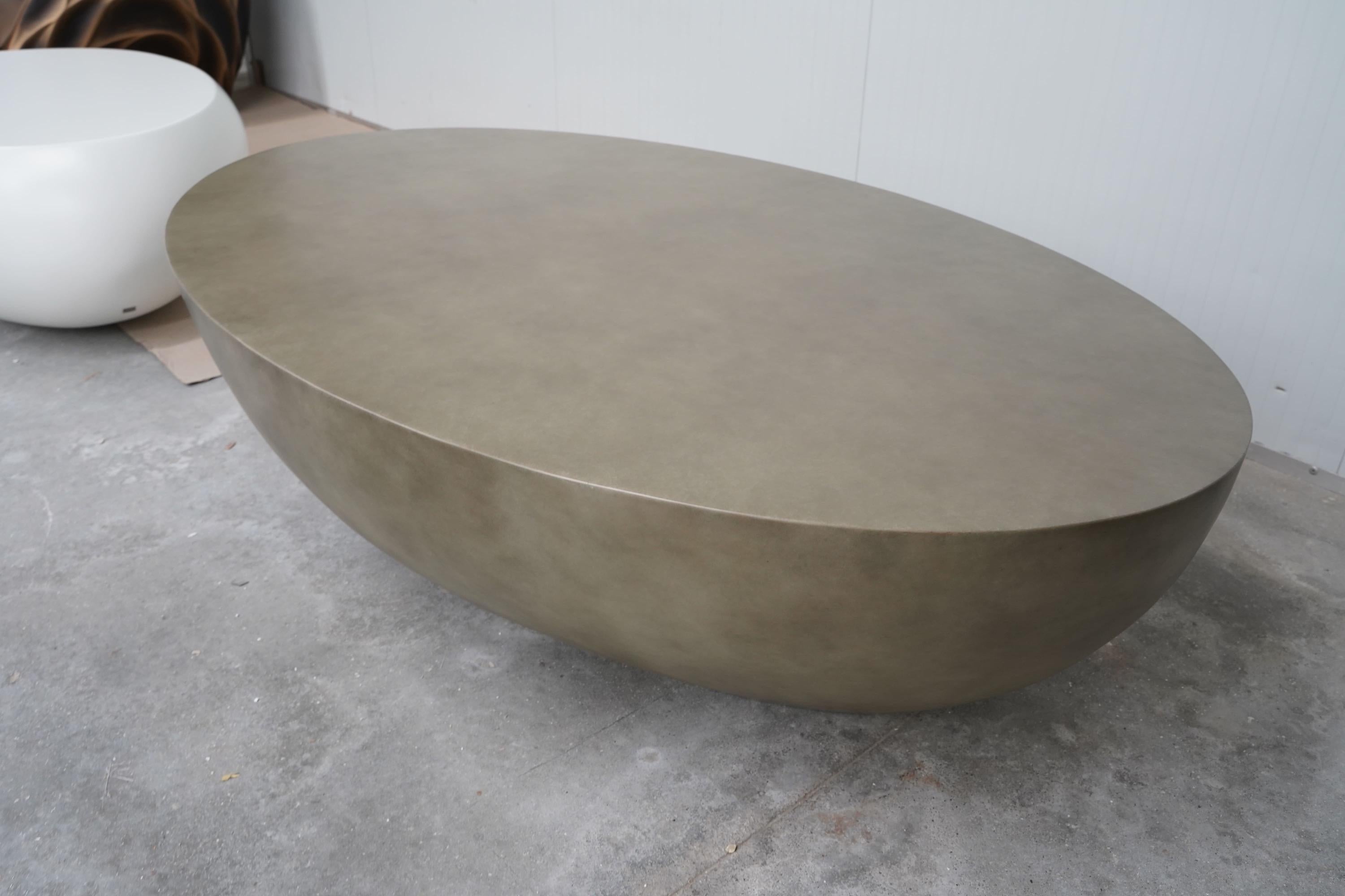 Mesa de centro contemporánea para exterior/interior construida con fibra de vidrio reforzada con resina. Este material altamente resistente es muy duradero y requiere menos mantenimiento que el hormigón. La mesa se ofrece en fibra de vidrio natural