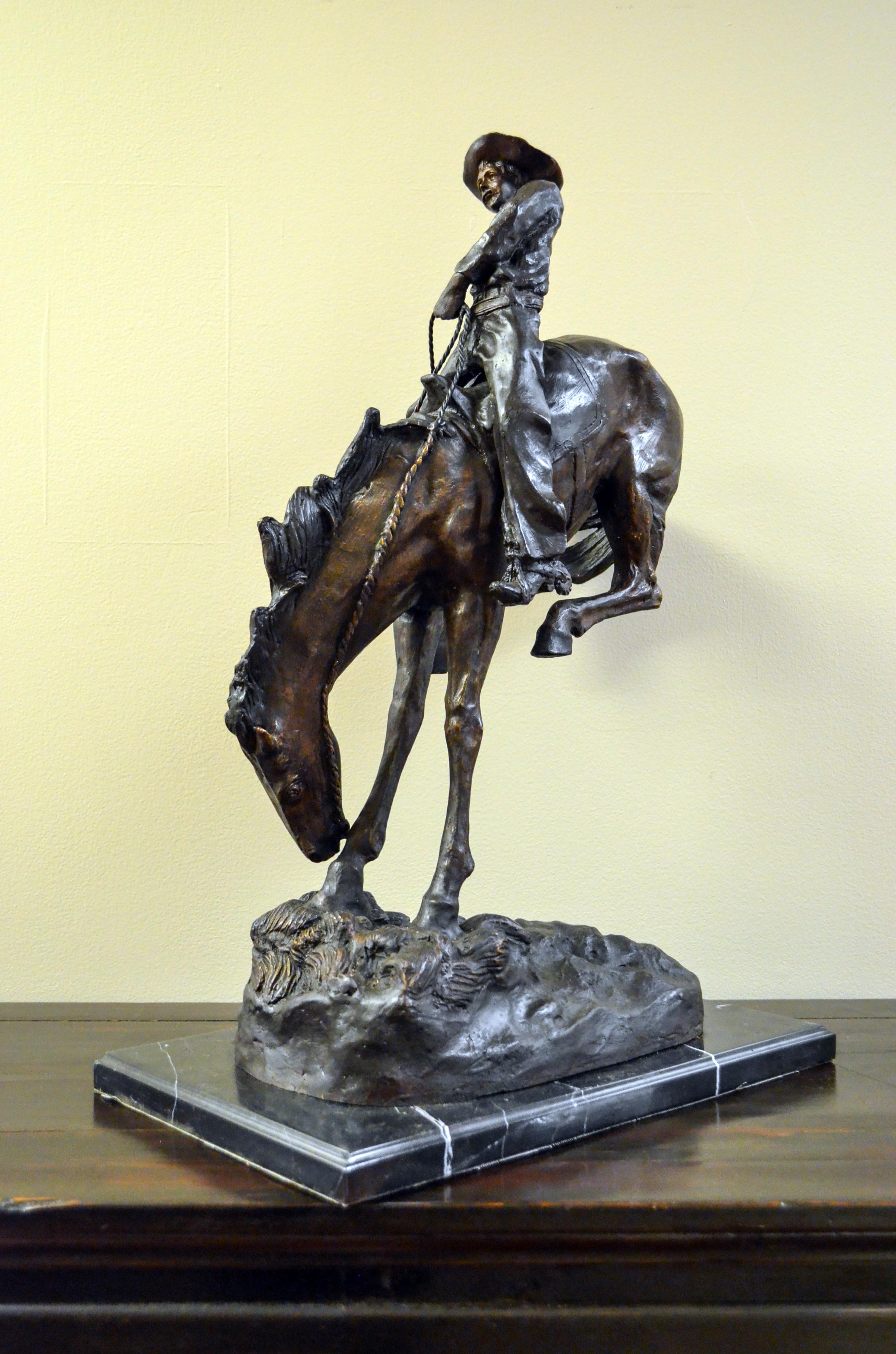 Outlaw, a cast bronze sculpture after American artist Frederic Remington's 1906 original, on marble base. Filled with a tremendous dramatic tension, this bronze sculpture depicts a scene from the American Old West particularly dear to Frederic