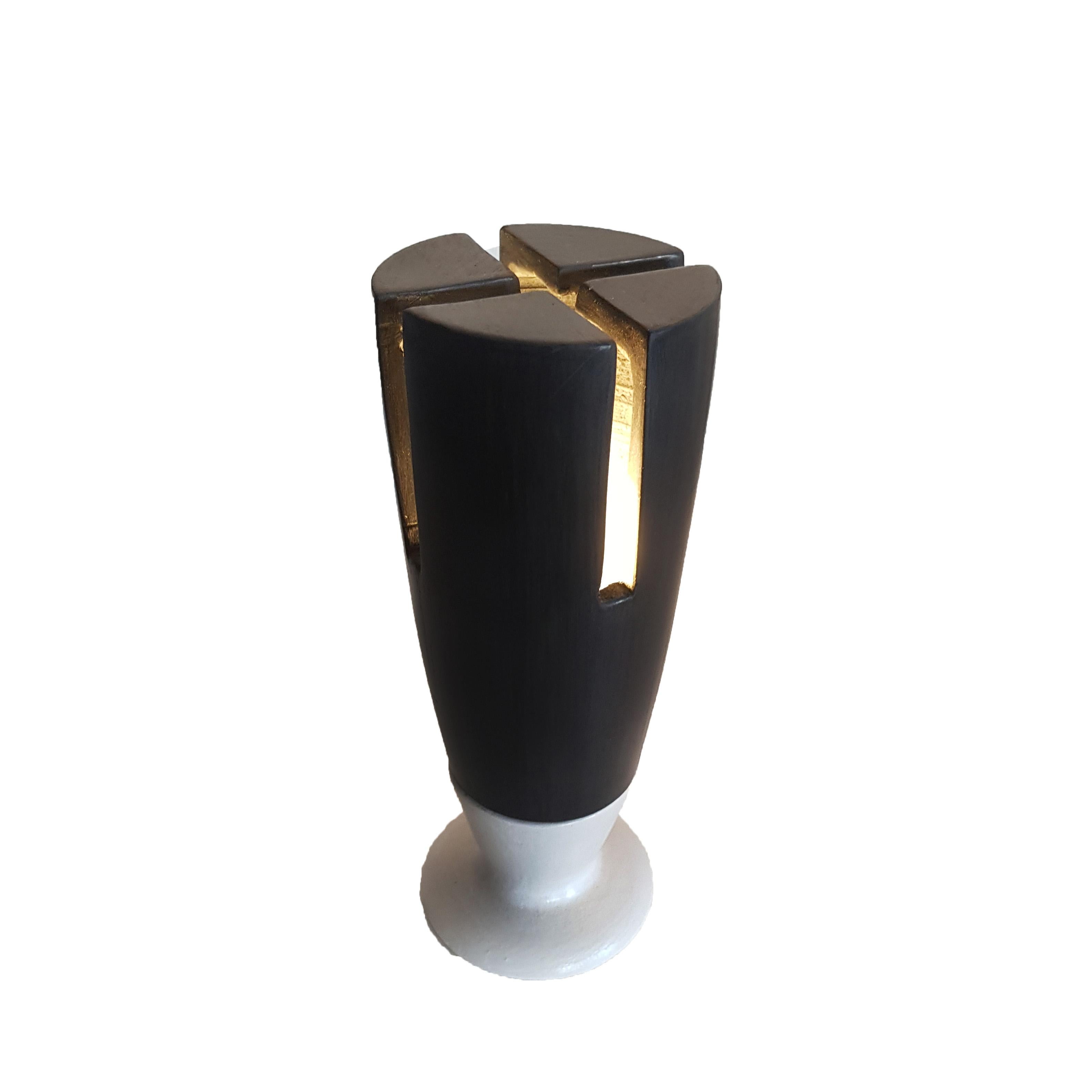 Table lamp made of bucchero and earthenware, which recalls medieval European architecture.
This item brings together minimalism and postmodernism.
The light radiating through the slits give this object a magical and timeless effect.
It is a