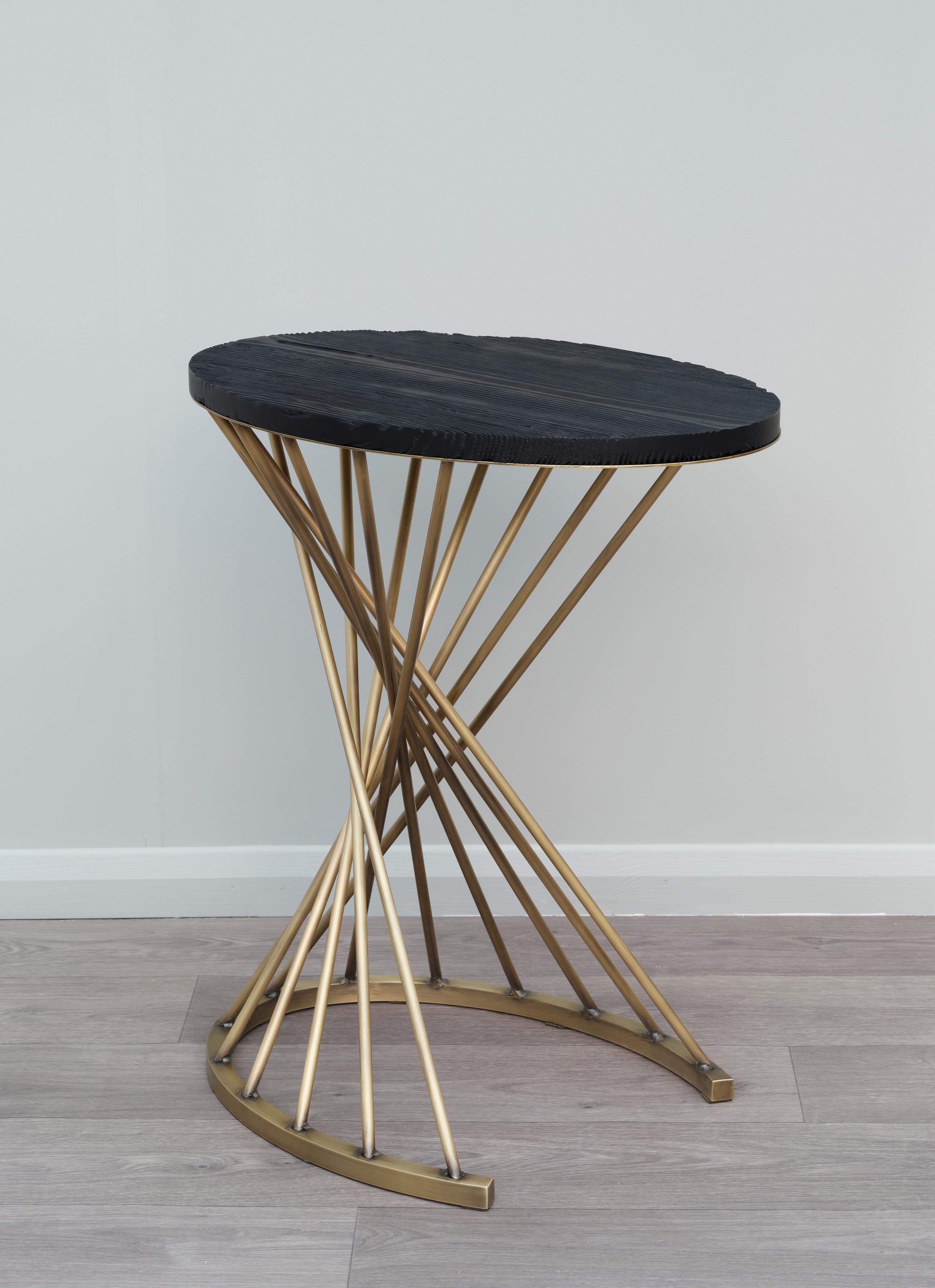 Contemporary Handcrafted Side Table in Brass and Wood.

Outrenoir Orpheus side table is an intricate piece with top in darkened pine wood and supported by patinated brass legs forming a helix. 

The shape and the title of this work, which references