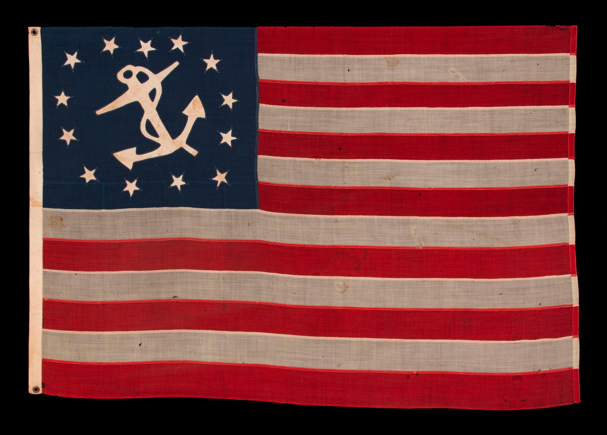 OUTSTANDING, 13 STAR, ANTIQUE AMERICAN PRIVATE YACHT ENSIGN WITH GREAT FOLK QUALITIES THAT INCLUDE AN UNUSUALLY WIDE ANCHOR AND A DECIDEDLY LOPSIDED RING OF 13 STARS; MADE DURING THE 2ND HALF OF THE 19TH CENTURY; ITS DEVICE HAND-SEWN AND