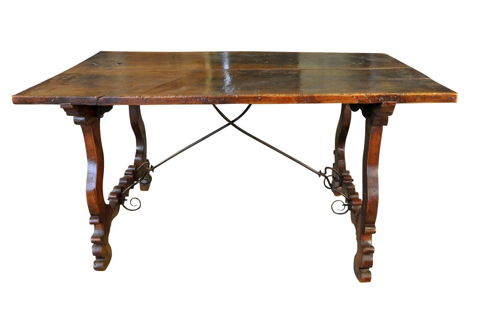 An outstanding 17th century Spanish table masterly constructed from walnut and hand-forged double pronged iron stretchers. Sensational patina - so very rich and luminous. Perfect as a smaller dining table or writing table.