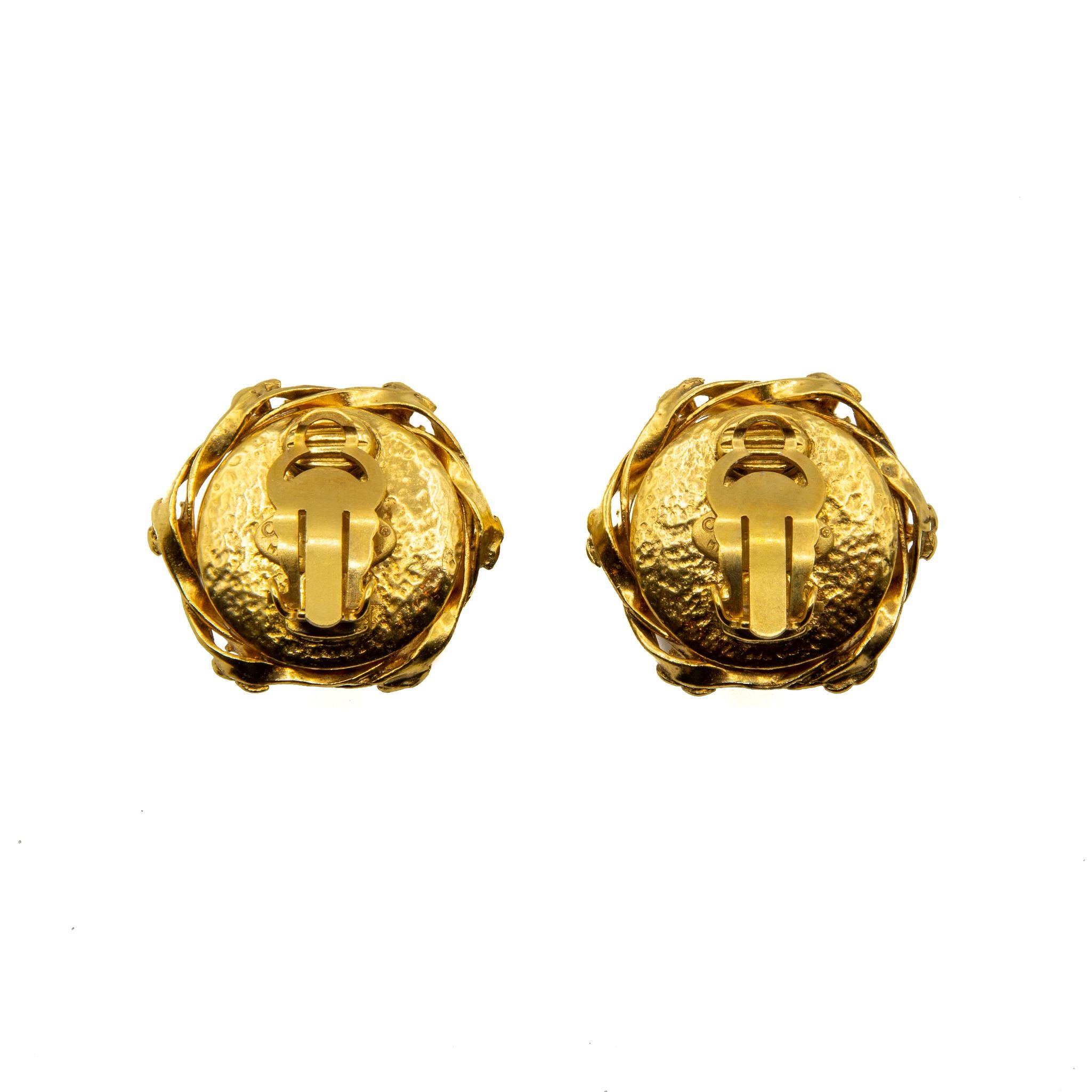 Outstanding 1995 Faux Pearl and Gilt Metal Clip-on Earrings. These earrings feature a large central faux pearl with 6 House logos woven around the edge with gold coloured gilt metal. This piece features the Chanel authenticity plaque. Provenience