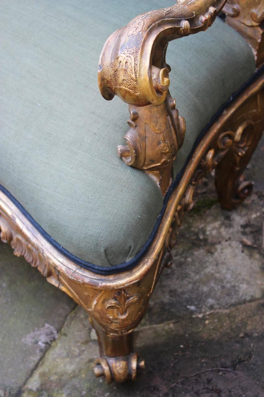 A fine quality and large 19th century Italian carved giltwood sofa of curved outline and wonderful proportions, retaining the original gilding and reupholstered by us in an antique hand-dyed linen with contrasting piping. 

This elegant sofa will