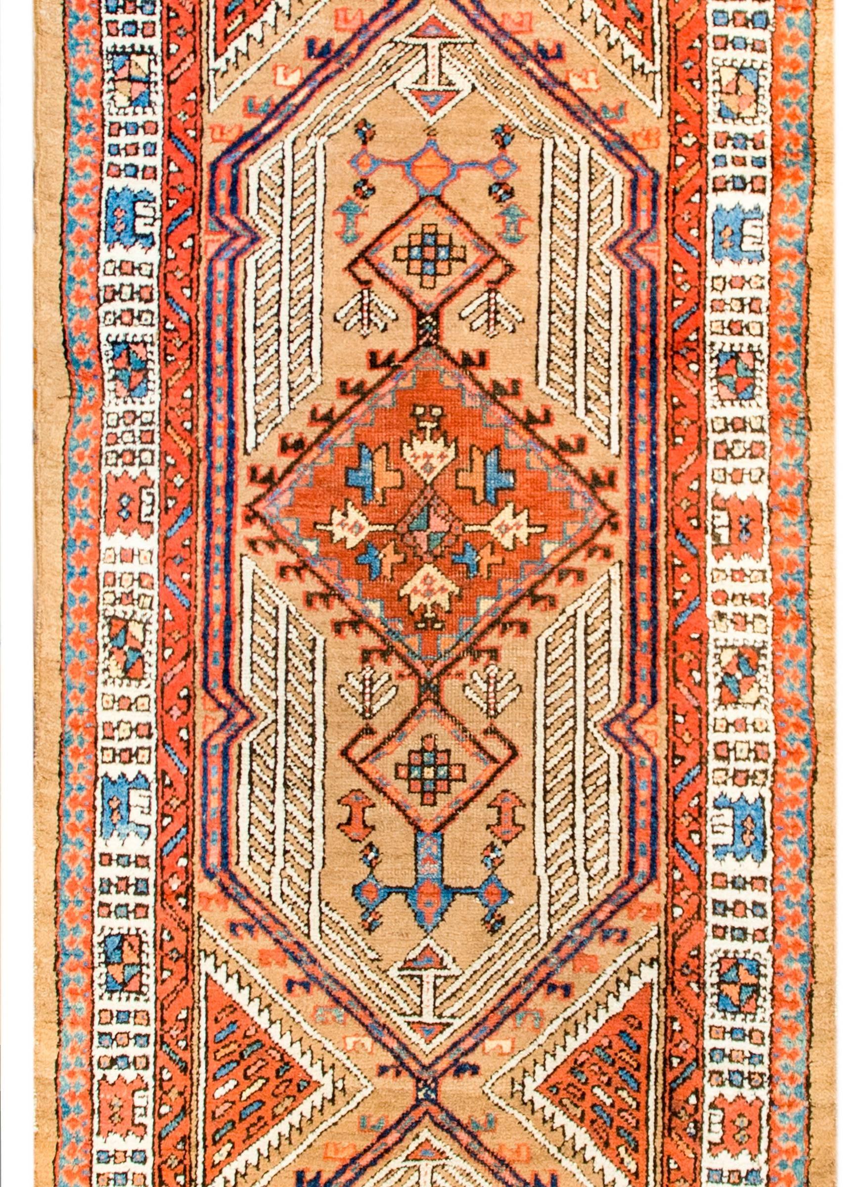 An amazing 19th century Persian Serab camel-hair runner with three large diamond medallions amidst a field of trees, vines, and flowers. The border is amazing with multiple geometric patterned stripes.