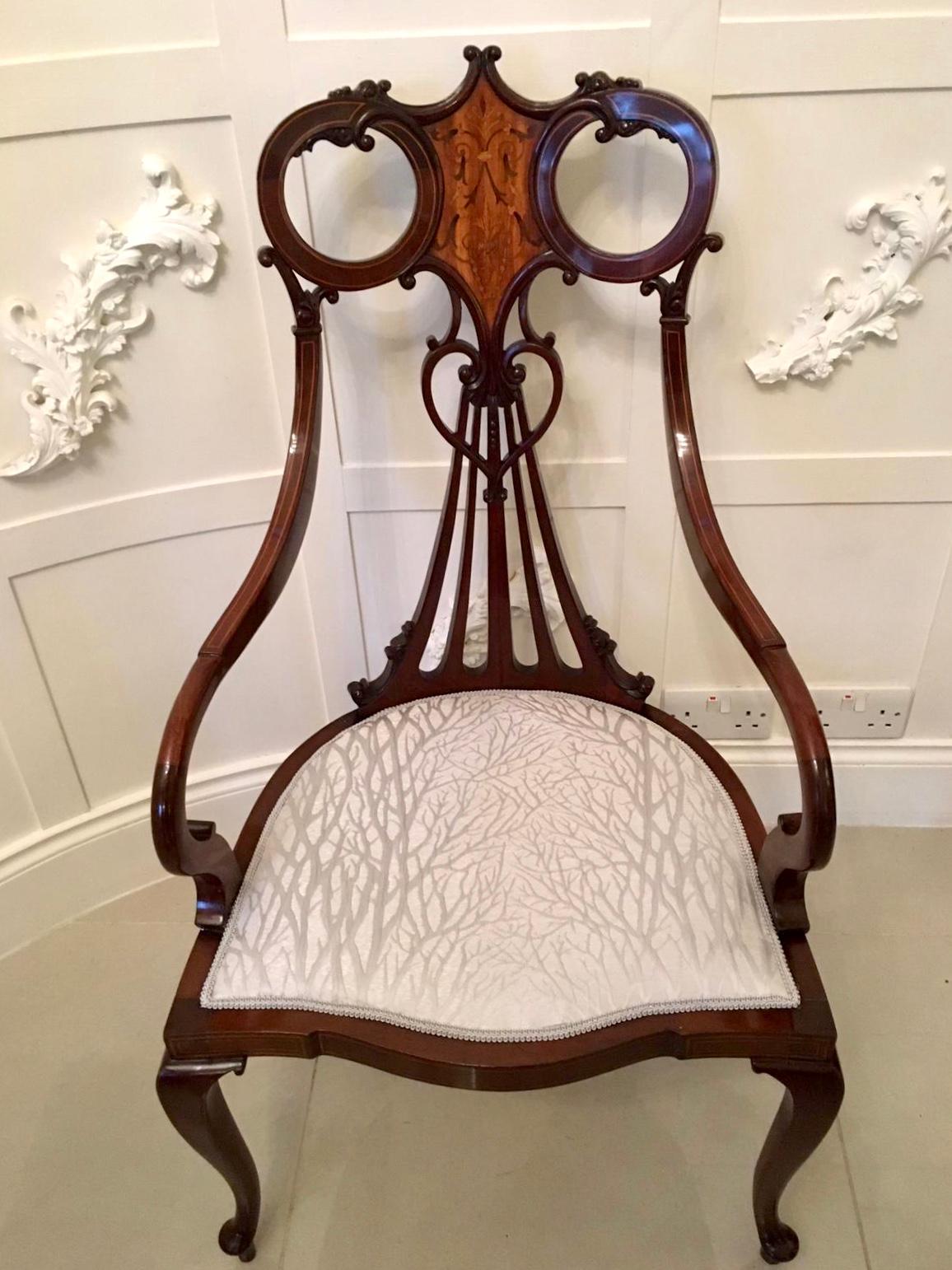 Outstanding antique 19th century Victorian antique mahogany inlaid armchair having an unusual beautifully shaped top rail with a quality satinwood inlaid panel. It boasts a pretty heart shaped carved centre splatt to the back. The open arms are