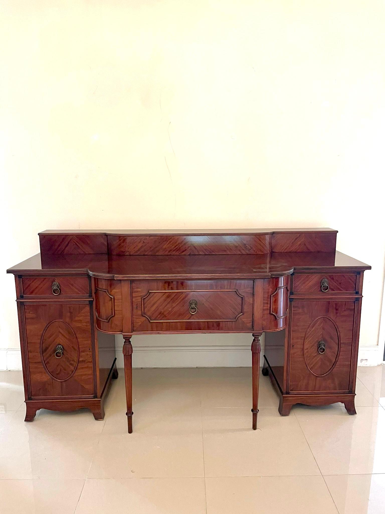 Outstanding quality antique Edwardian mahogany sideboard having a quality mahogany gallery back above a shaped mahogany top with a reeded edge above a figured mahogany moulded door flanked by two bow fronted moulded sides with original brass lions