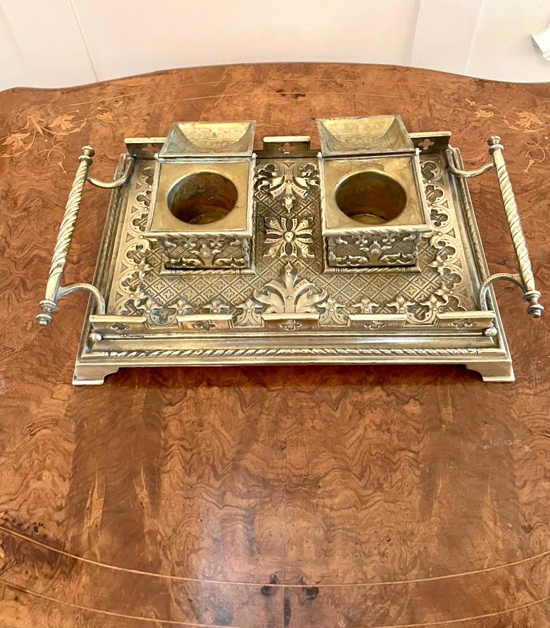 Outstanding antique Victorian brass desk set having two brass inkwells with lift up lids. It boasts a magnificent gothic ornate brass decoration and has two shaped carrying handles standing on shaped bracket feet.

A beautiful decorative piece in