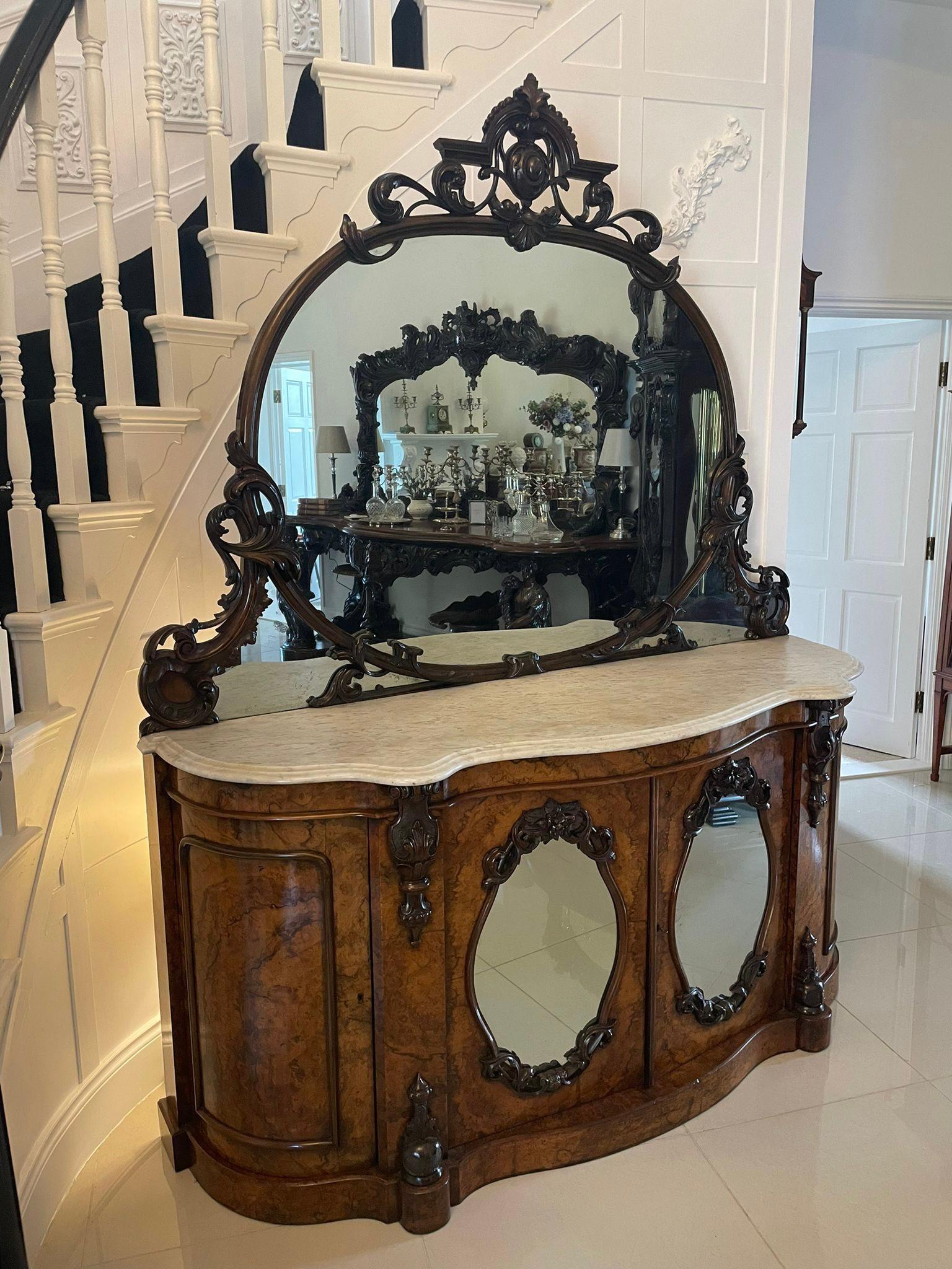 Outstanding quality antique Victorian burr walnut and carved mirror back credenza having an outstanding quality carved shaped mirror back above a serpentine shaped white marble top with a double moulded edge above a pair of burr walnut oval, carved
