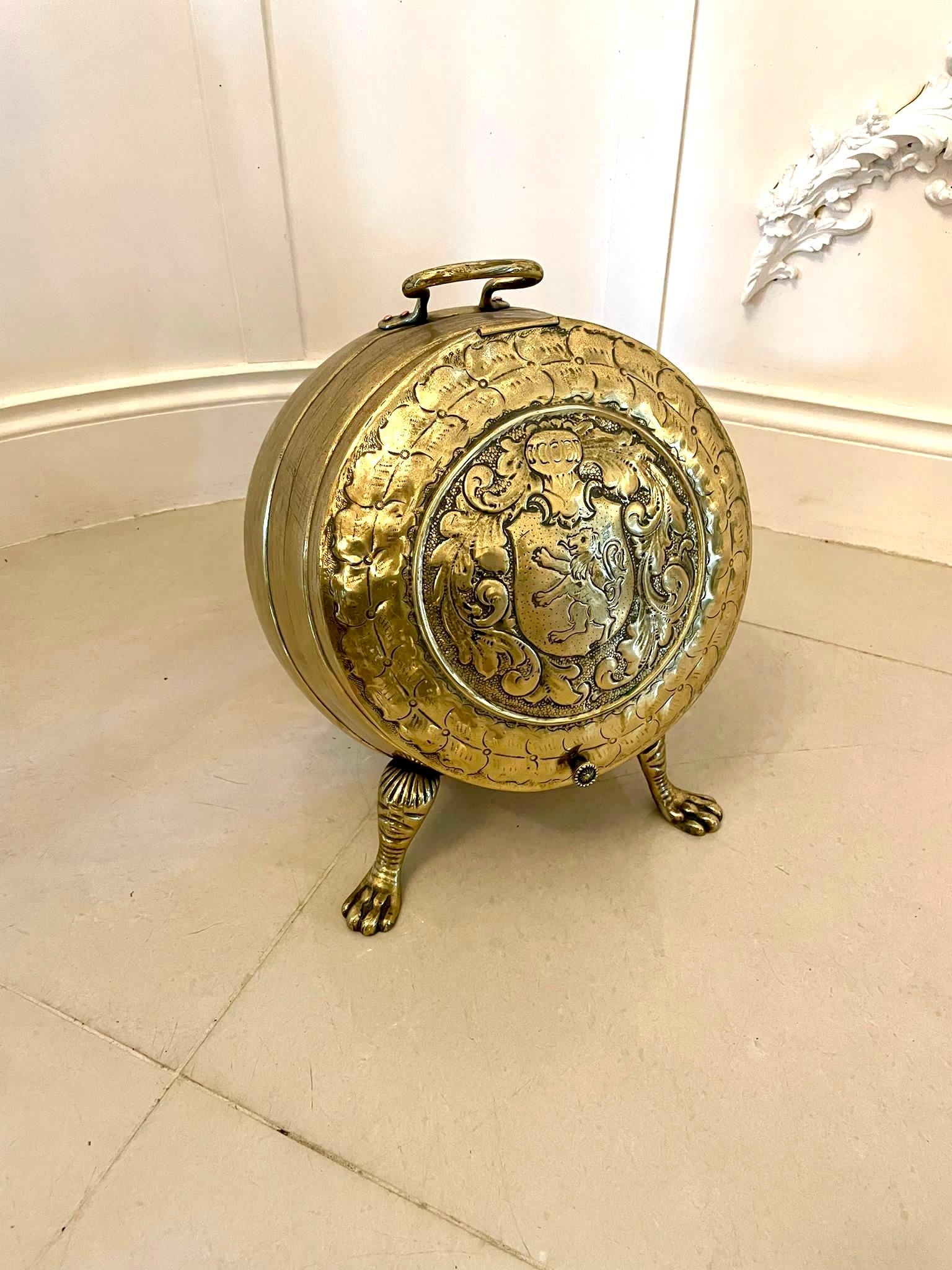 Outstanding quality antique Victorian ornate brass coal bucket of barrel shape and having a carrying handle above a hinged lid decorated with armorials and opening to reveal a removable tin liner standing on claw feet.

A splendid decorative piece