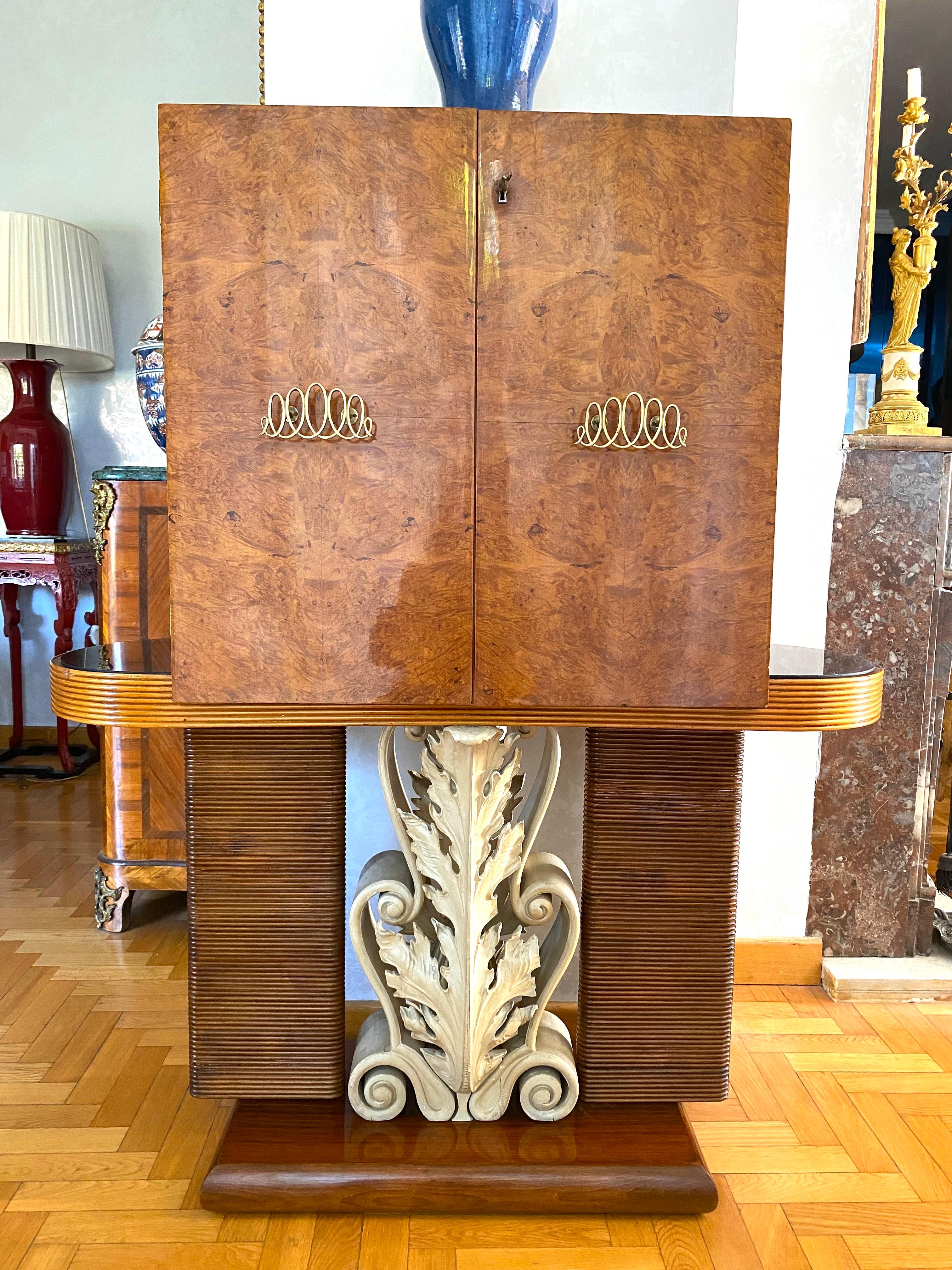Unusual and rare bar cabinet designed by Pier Luigi Colli. Features finely carved and painted legs decorated with acanthus leaves.
Decorated front doors centered by a bar cabinet with mirror.
Outstanding elegant piece.
  