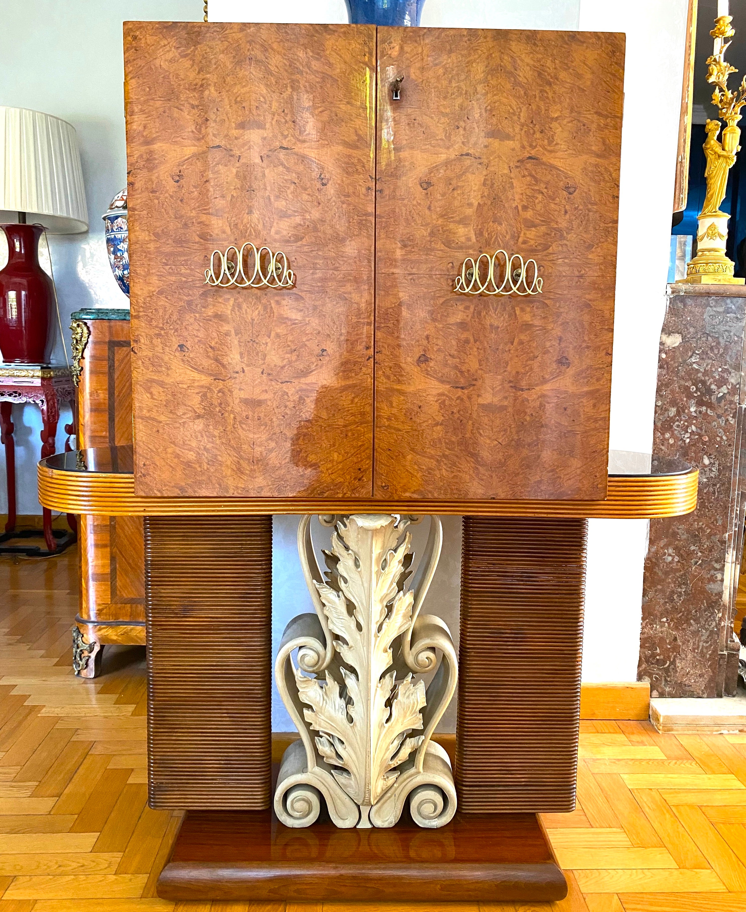 Unusual and rare bar cabinet designed by Pier Luigi Colli. Features finely carved and painted legs decorated with acanthus leaves.
Decorated front doors centered by a bar cabinet with mirror.
Outstanding elegant piece.
  