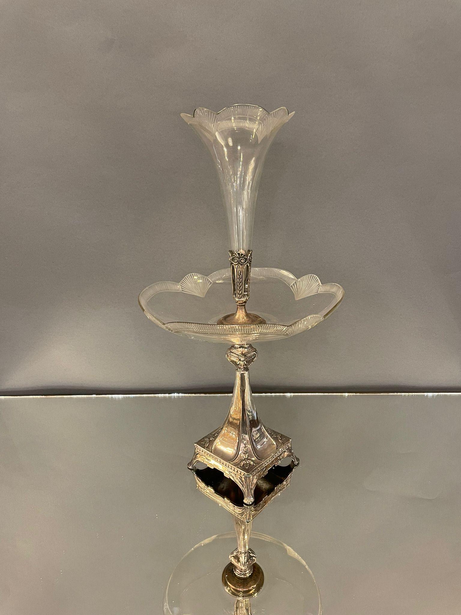 A French Art Nouveau epergne from the 19th century, with silver plate base and crystal vase. Born in France during the second half of the 19th century, this exquisite centrepiece features a Rococo inspired silver candlestick, resting on a tripartite