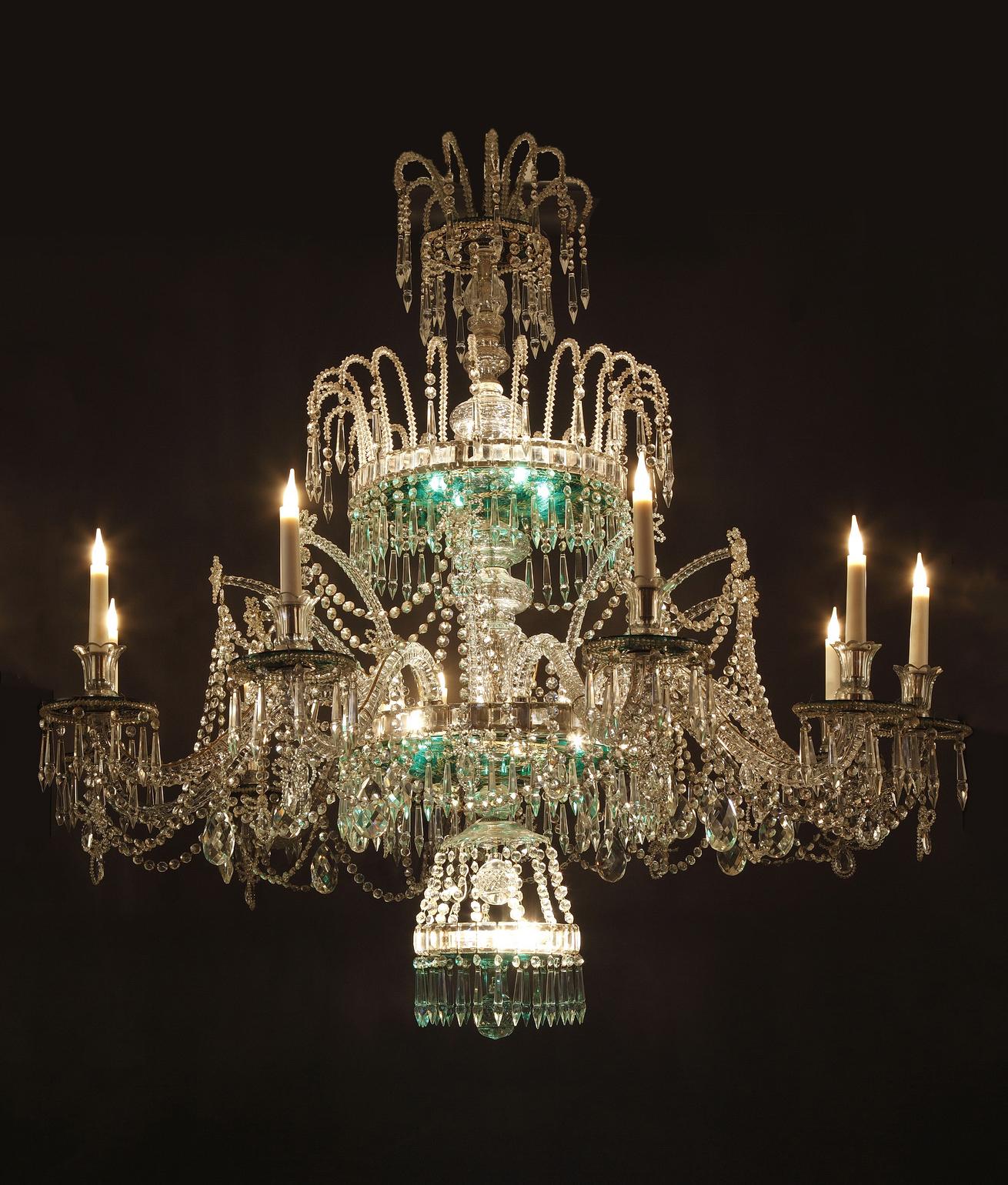 A magnificent cut crystal three-stage chandelier attributed to the Crystal Manufacture of the Granja, underlined by crown of prisms, pearls and mirza. The lower part holds ten light arms finishing by green crystal cups with gold foliate patterns.