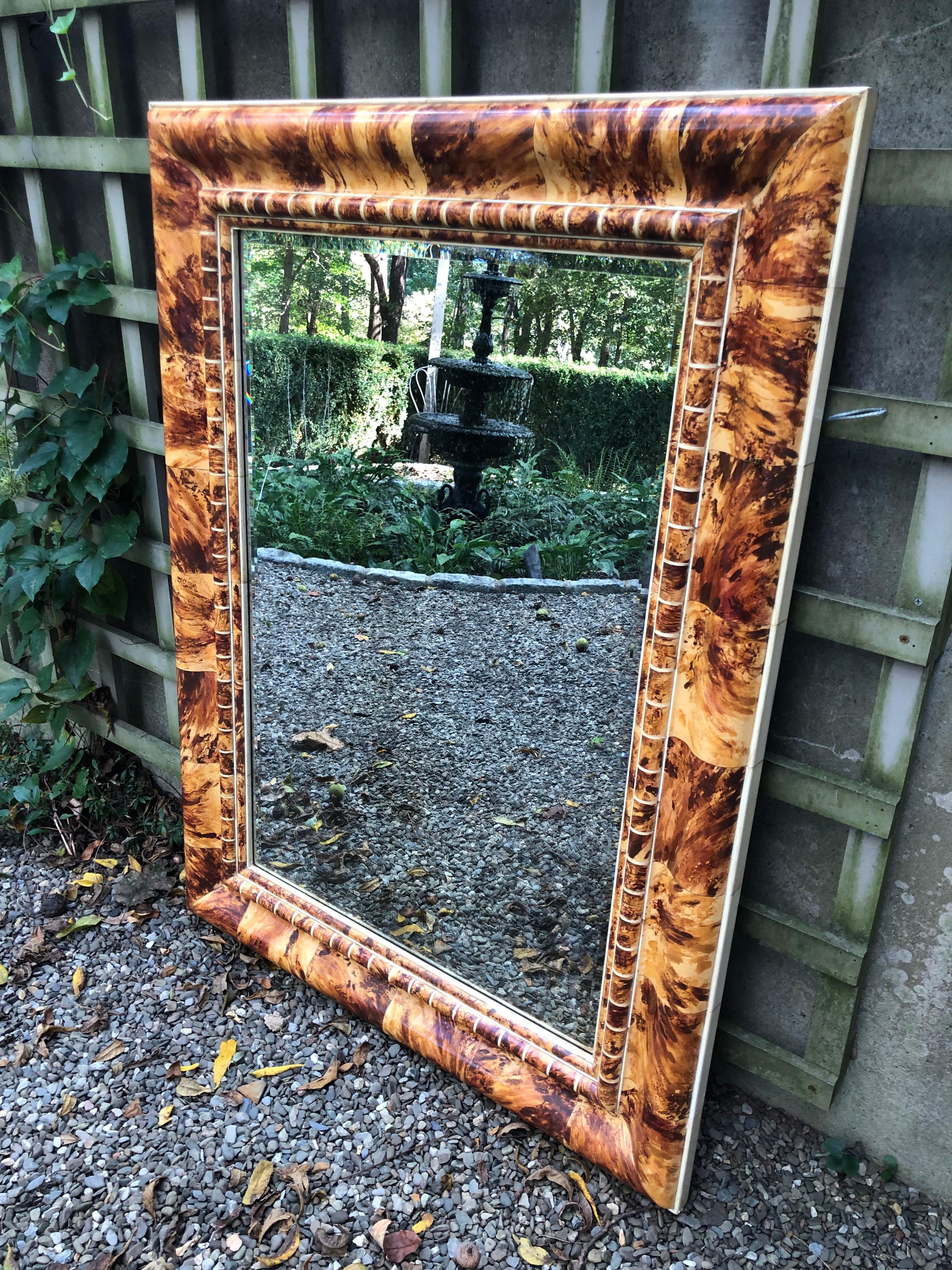 Outstanding custom mirror in faux tortoise shell painted by the renowned Isabel O’Neil Studio, New York City. Painting is extremely realistic with varying shades of brown and ivory. Lacquered finish. Mirror is aged glass and is beveled.
 