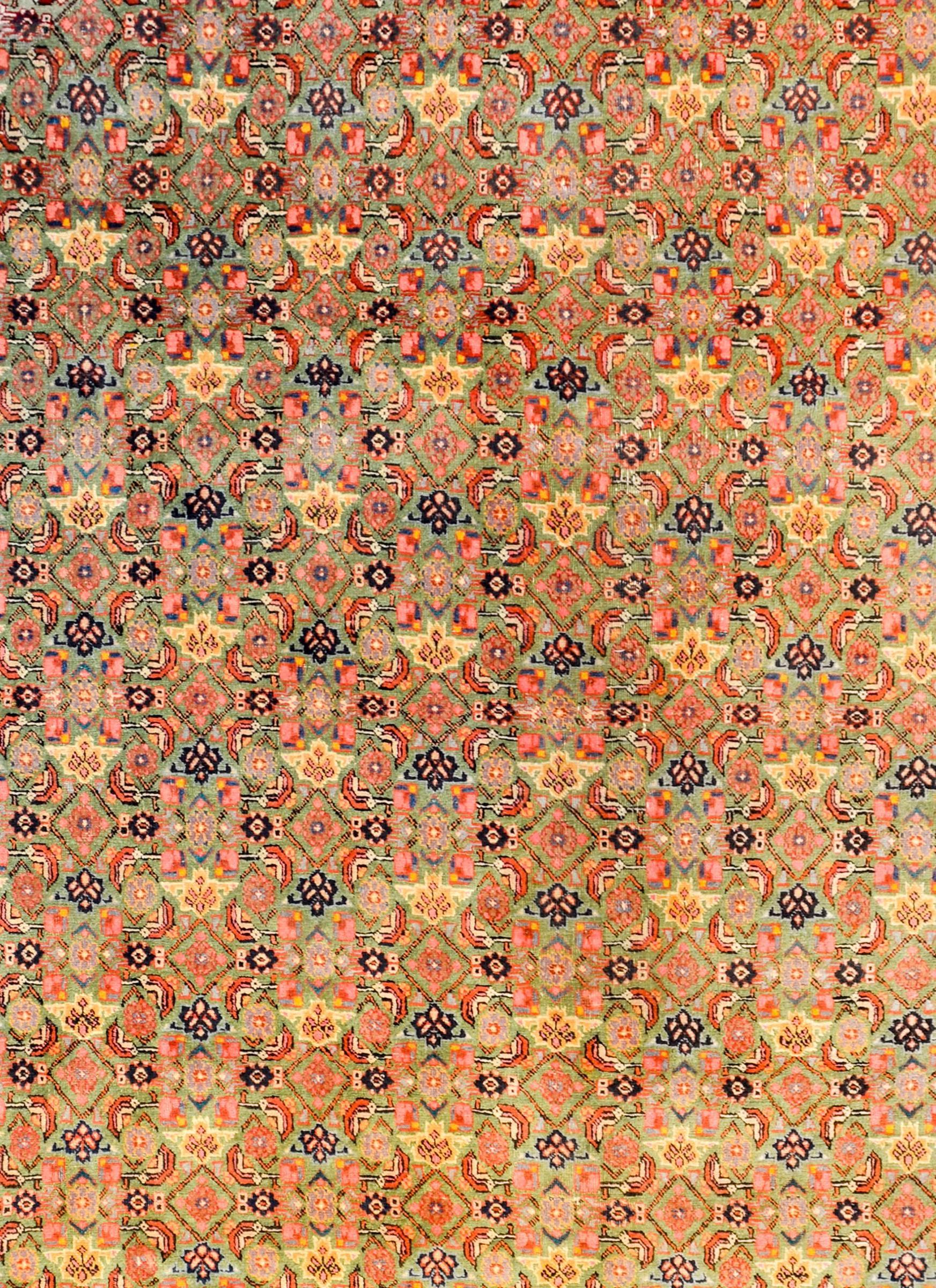 A wonderful early 20th century Persian Bidjar rug with an all-over lattice floral pattern woven in crimson, pink, gold, and indigo, on a beautiful lime green background. The border is unbelievable, with a unique large-scale stylized floral pattern