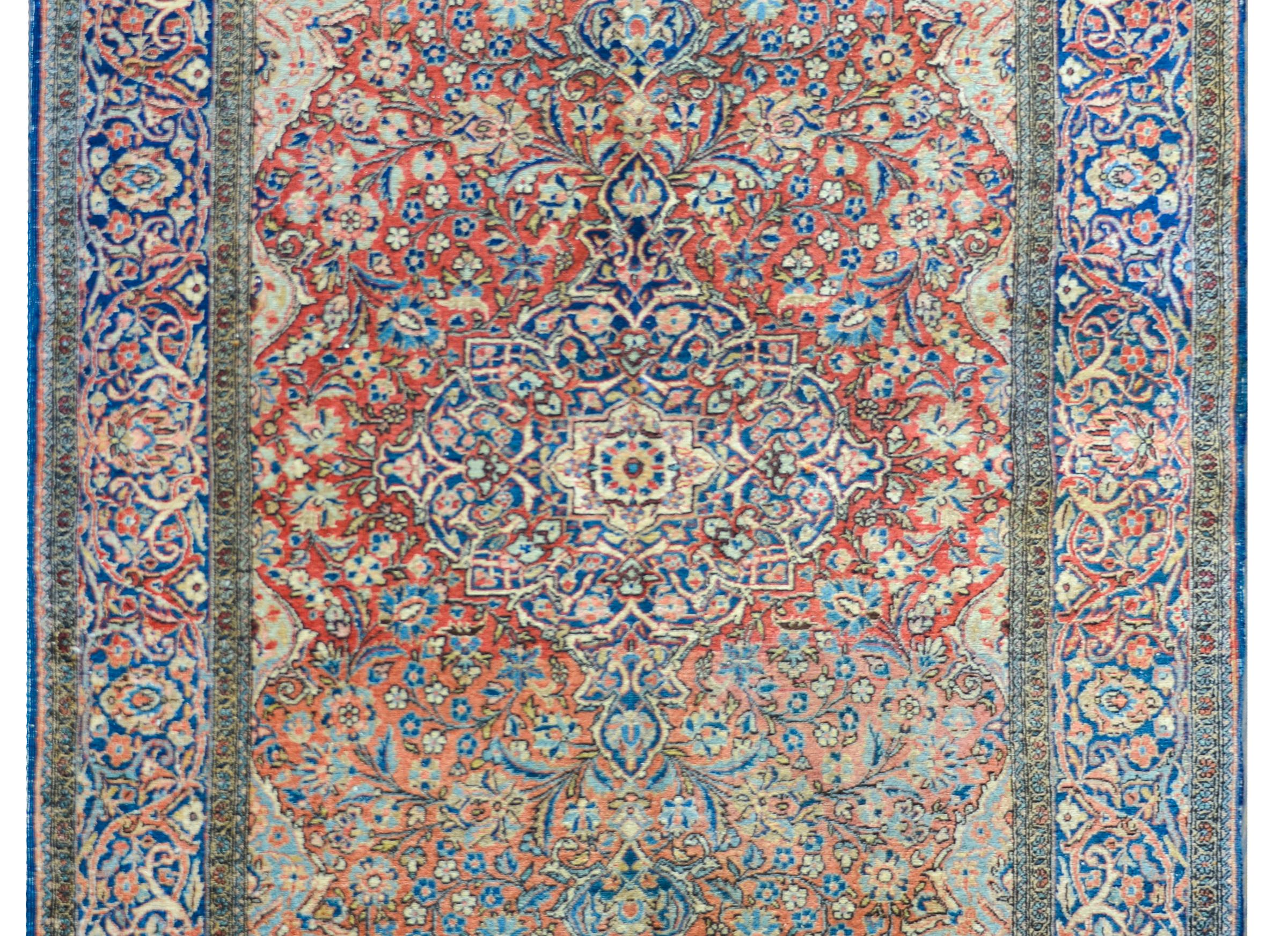 Excepcional alfombra persa kashan de principios del siglo XX con un medallón central muy elaborado y un campo floral tejido en bellos índigos, rosas, dorados y cremas sobre un fantástico fondo rojo abrash. El borde es igualmente bello, con varias