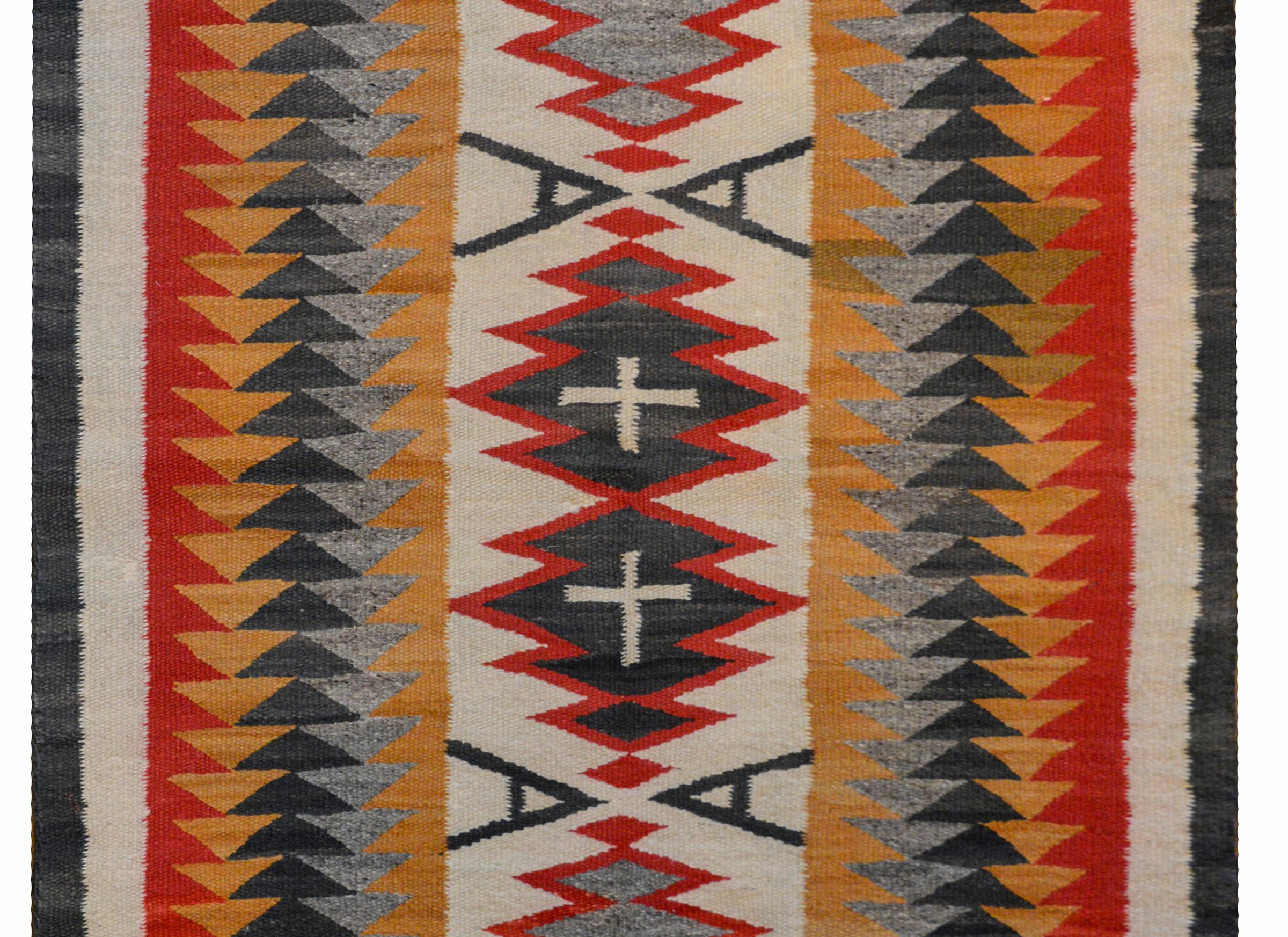 An outstanding early 20th century Navajo rug with four large medallions, two with white crosses flanked by pairs of black 