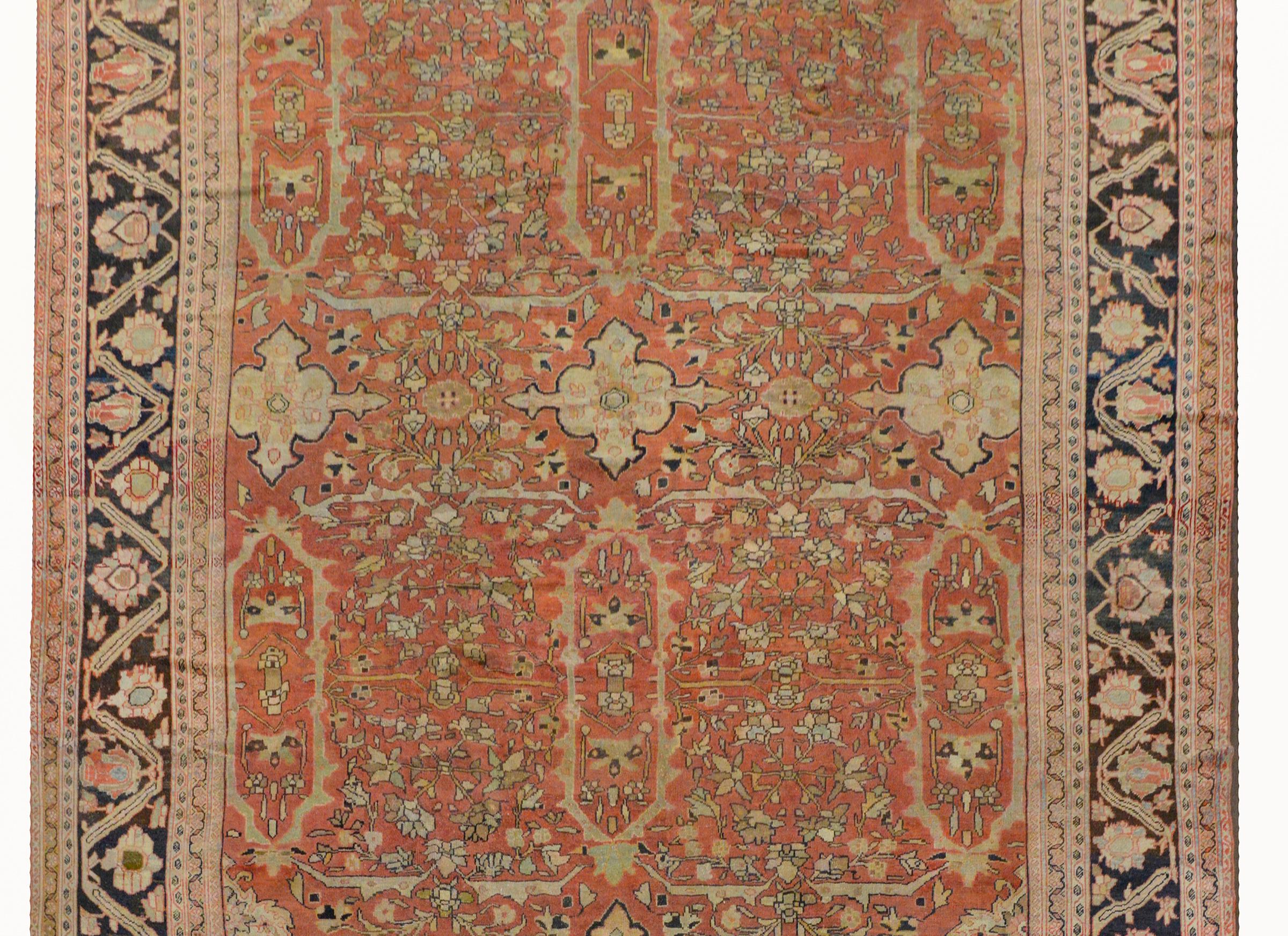 An outstanding early 20th century Persian palatial-scale Sultanabad rug with an exquisite all-over scrolling vine and floral pattern woven in pale colors of green, indigo, cream, and pink, and a soft salmon colored background. The border is wide