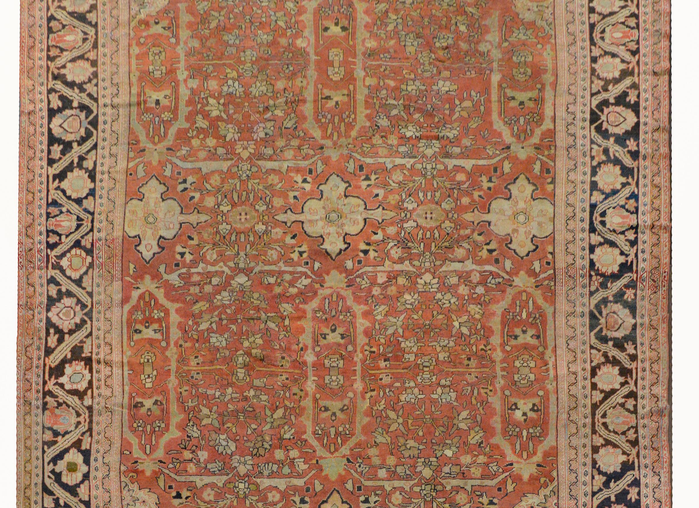 An outstanding early 20th century Persian palatial-scale Sultanabad rug with an exquisite all-over scrolling vine and floral pattern woven in pale colors of green, indigo, cream, and pink, and a soft salmon colored background. The border is wide