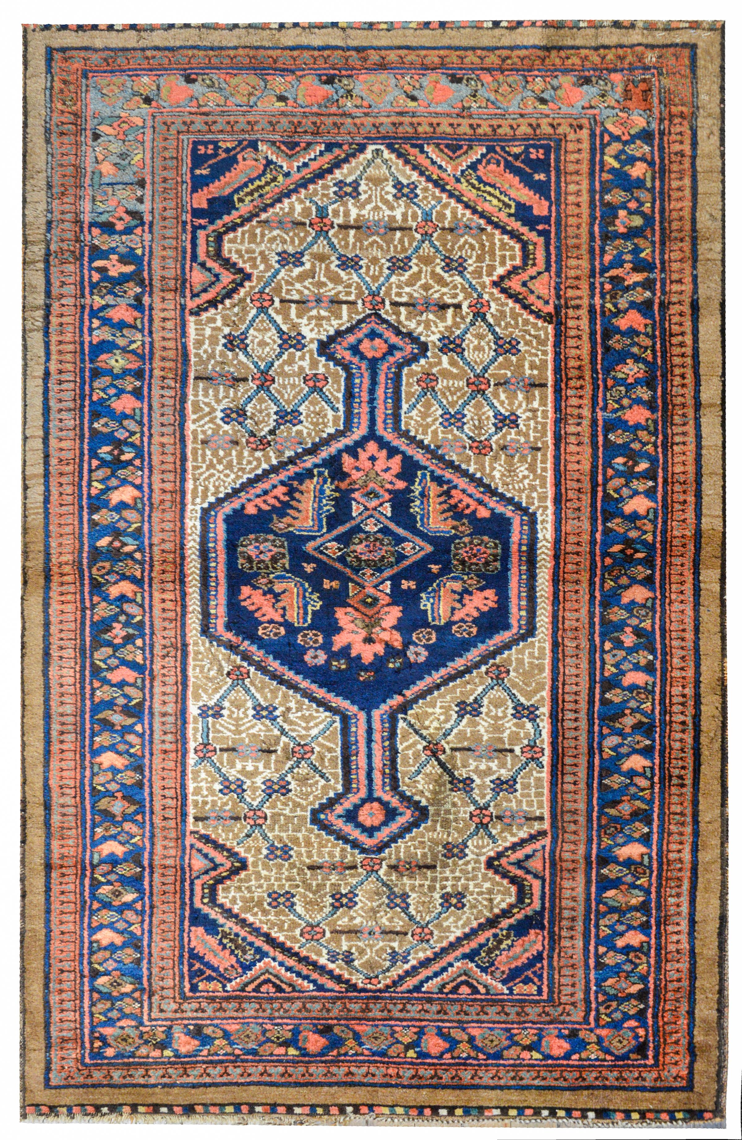 An outstanding early 20th century Persian Serab rug with a large hexagonal medallion with a floral patterned trellis pattern on a geometric camel colors background. The border is wonderful with a stylized floral pattern on an indigo background